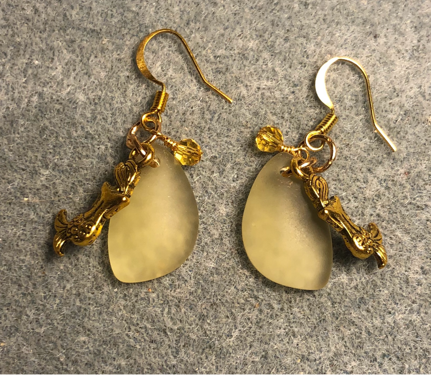 Small amber sea glass pendant bead earrings adorned with small gold mermaid charms and small amber Chinese crystal beads.