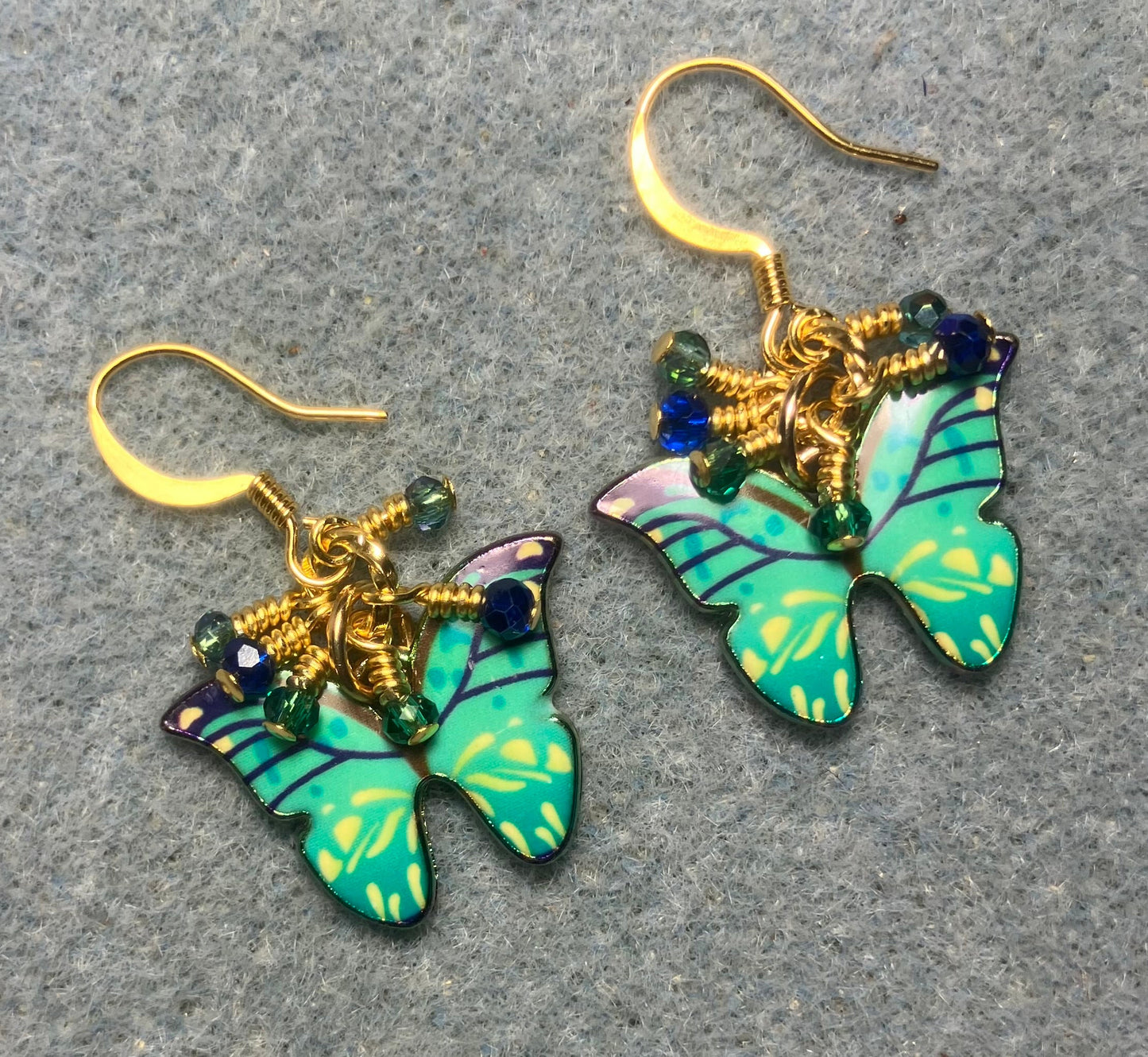 Green, aqua, and blue enamel butterfly charm earrings adorned with tiny dangling green, aqua, and blue Chinese crystal beads.