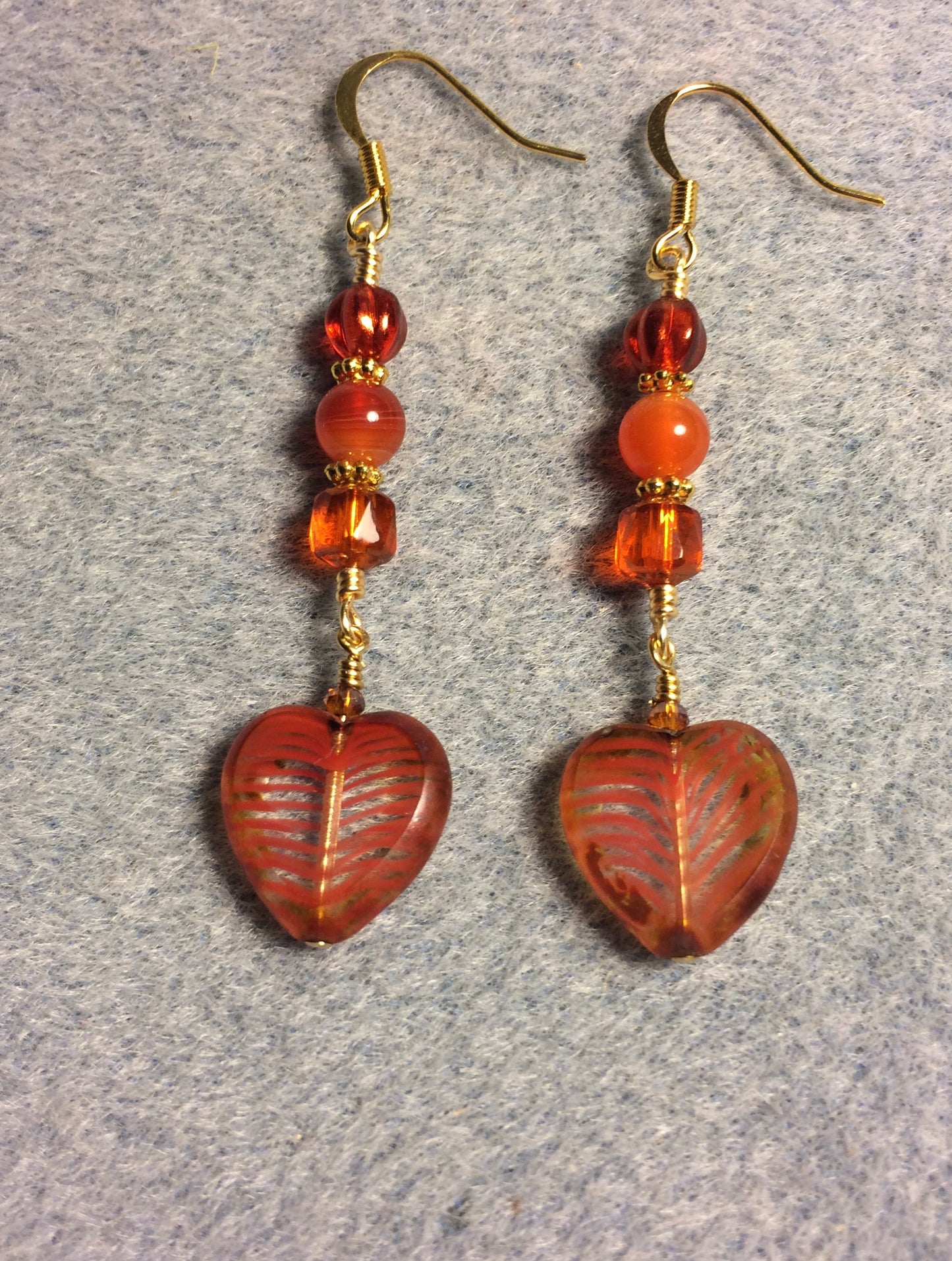 Orange striped Czech glass heart bead earrings adorned with orange Czech glass beads.