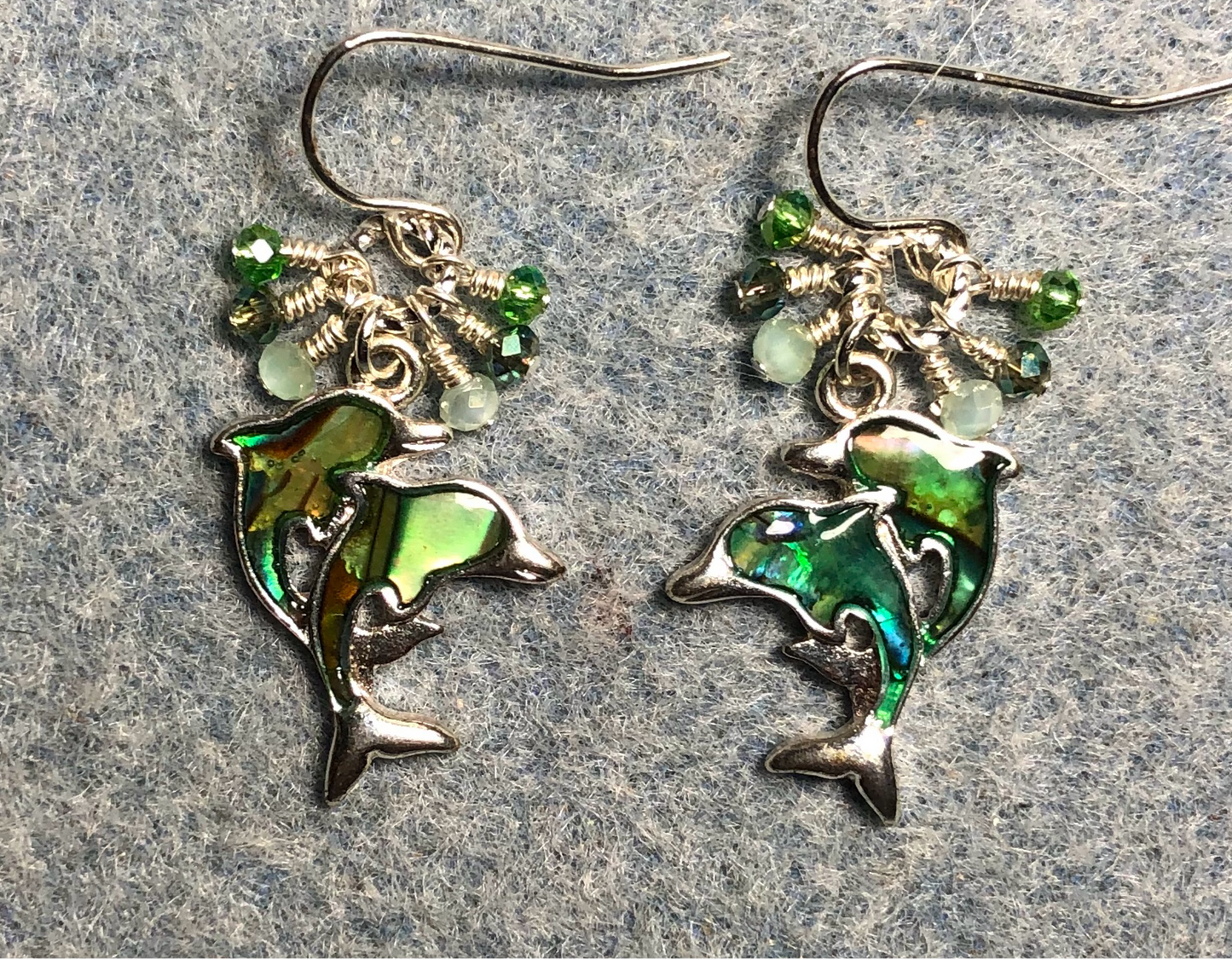 Mother and baby abalone dolphin charm earrings adorned with tiny dangling light green and olive green Czech glass beads.