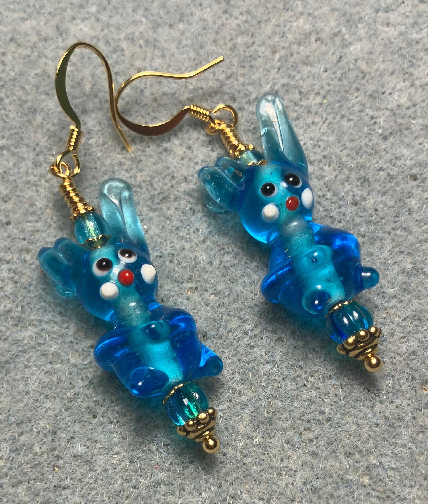 Translucent turquoise lamp work bunny rabbit bead earrings adorned with turquoise Czech glass beads.