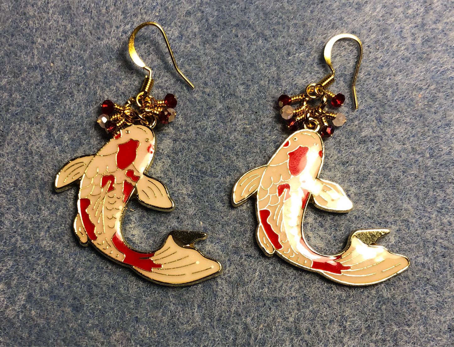 Large red and white enamel koi charm earrings adorned with tiny dangling red and white Chinese crystal beads.