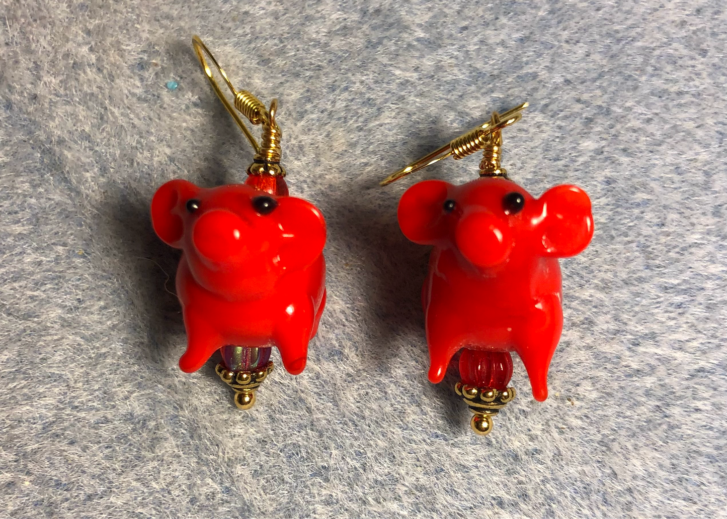 Opaque red lamp work pig bead earrings adorned with red Czech glass beads.