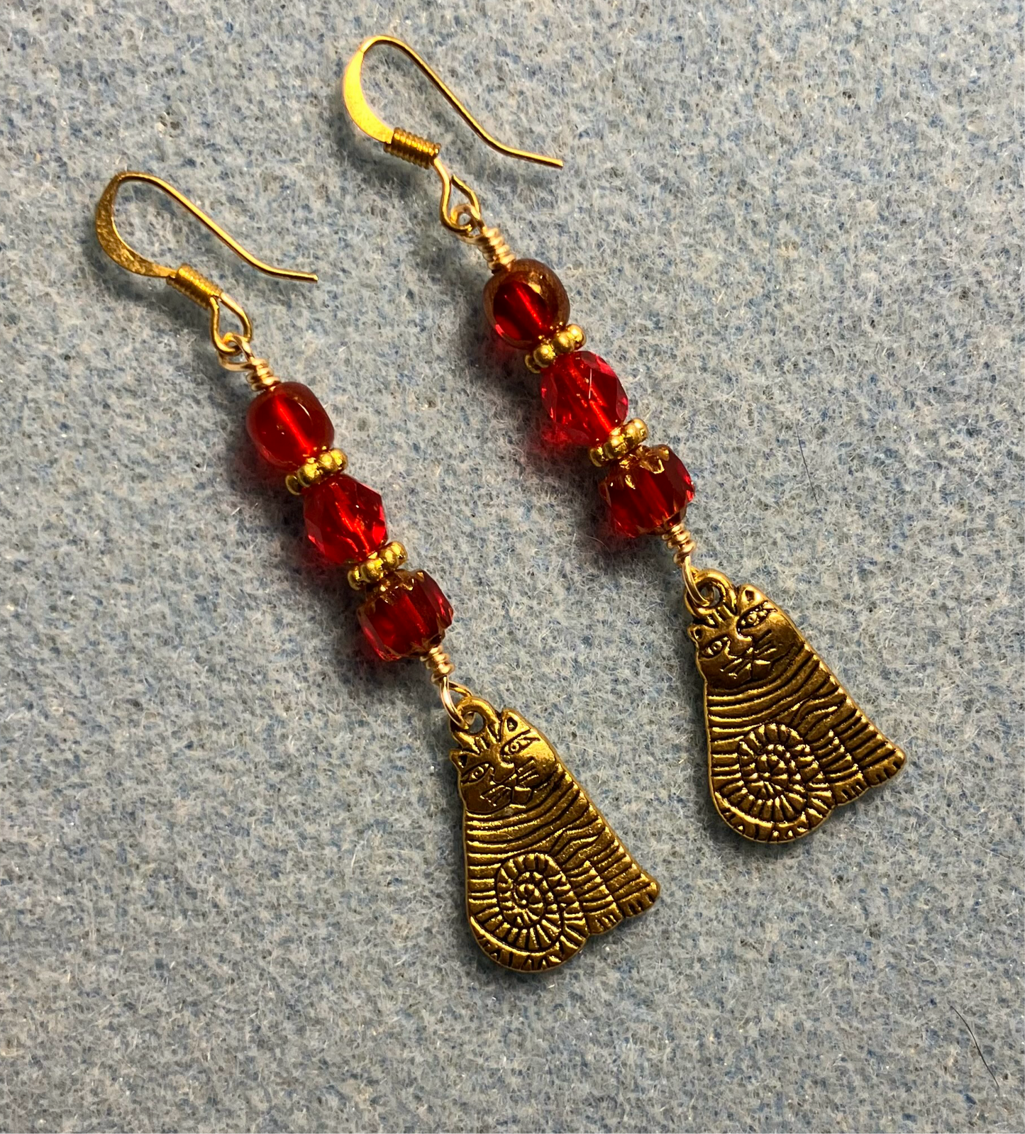 Gold sitting cat charm earrings adorned with red Czech glass beads