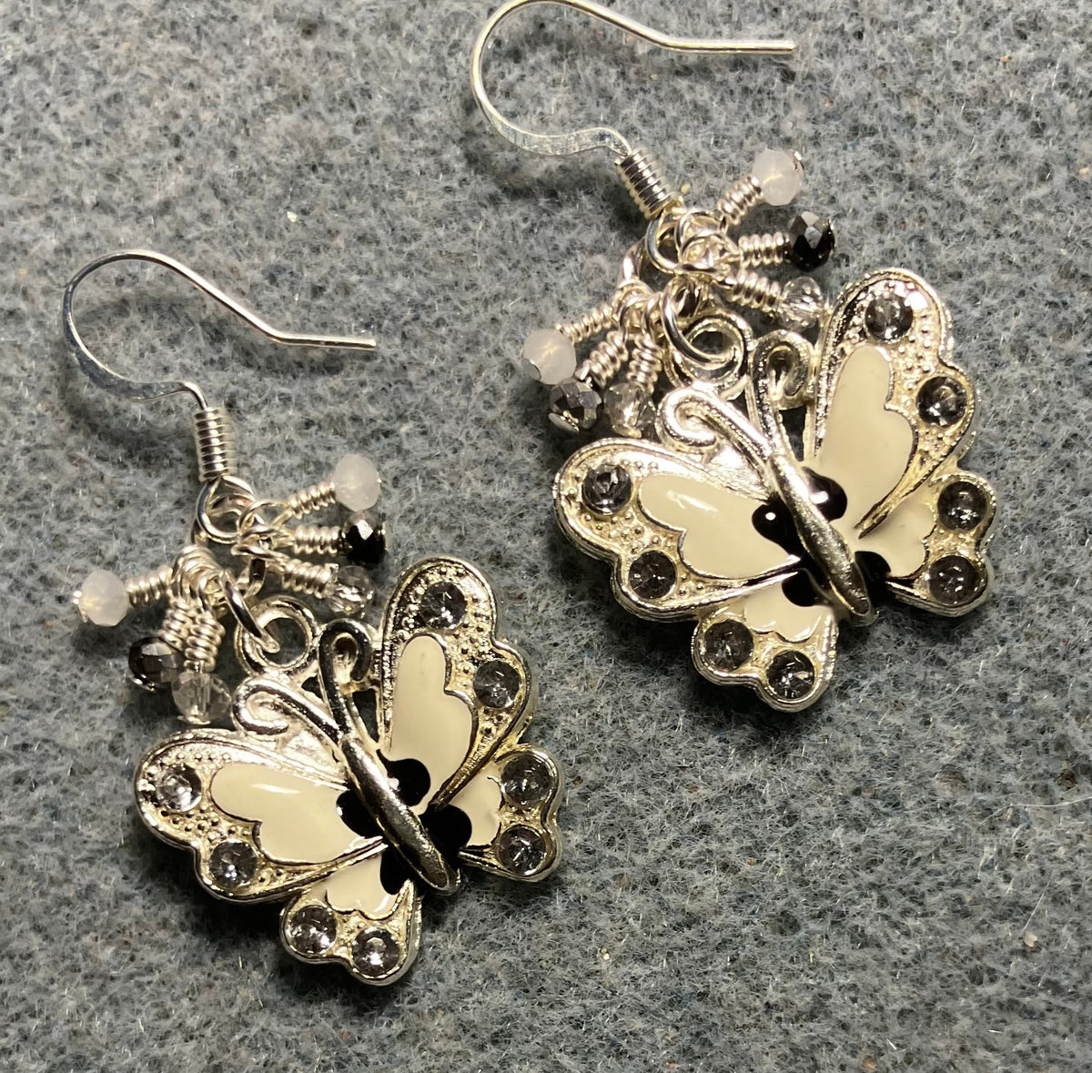 Silver, white, and black enamel and rhinestone butterfly charm earrings adorned with tiny dangling silver, white, and black Chinese crystal beads.