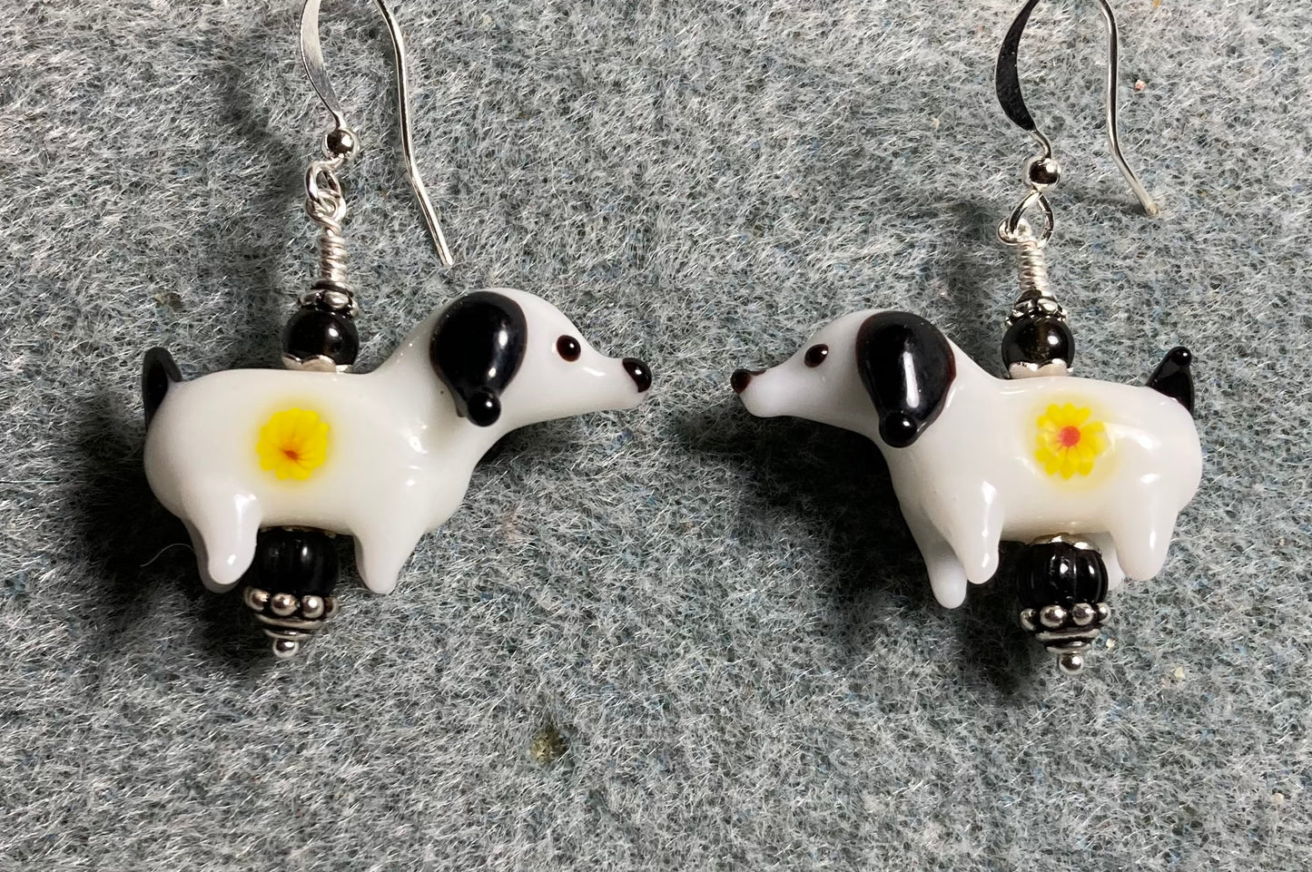 White, black, and yellow lamp work puppy dog bead earrings adorned with black Czech glass beads.