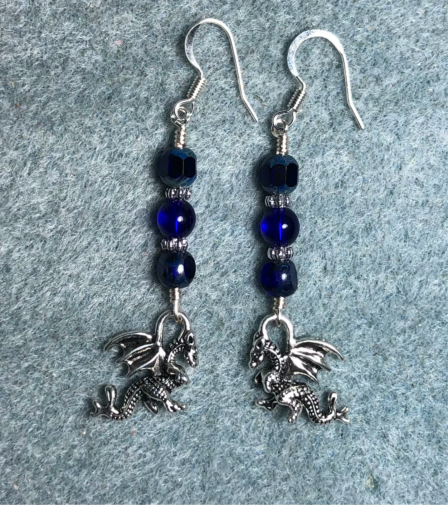 Silver dragon charm earrings adorned with dark blue Czech glass beads