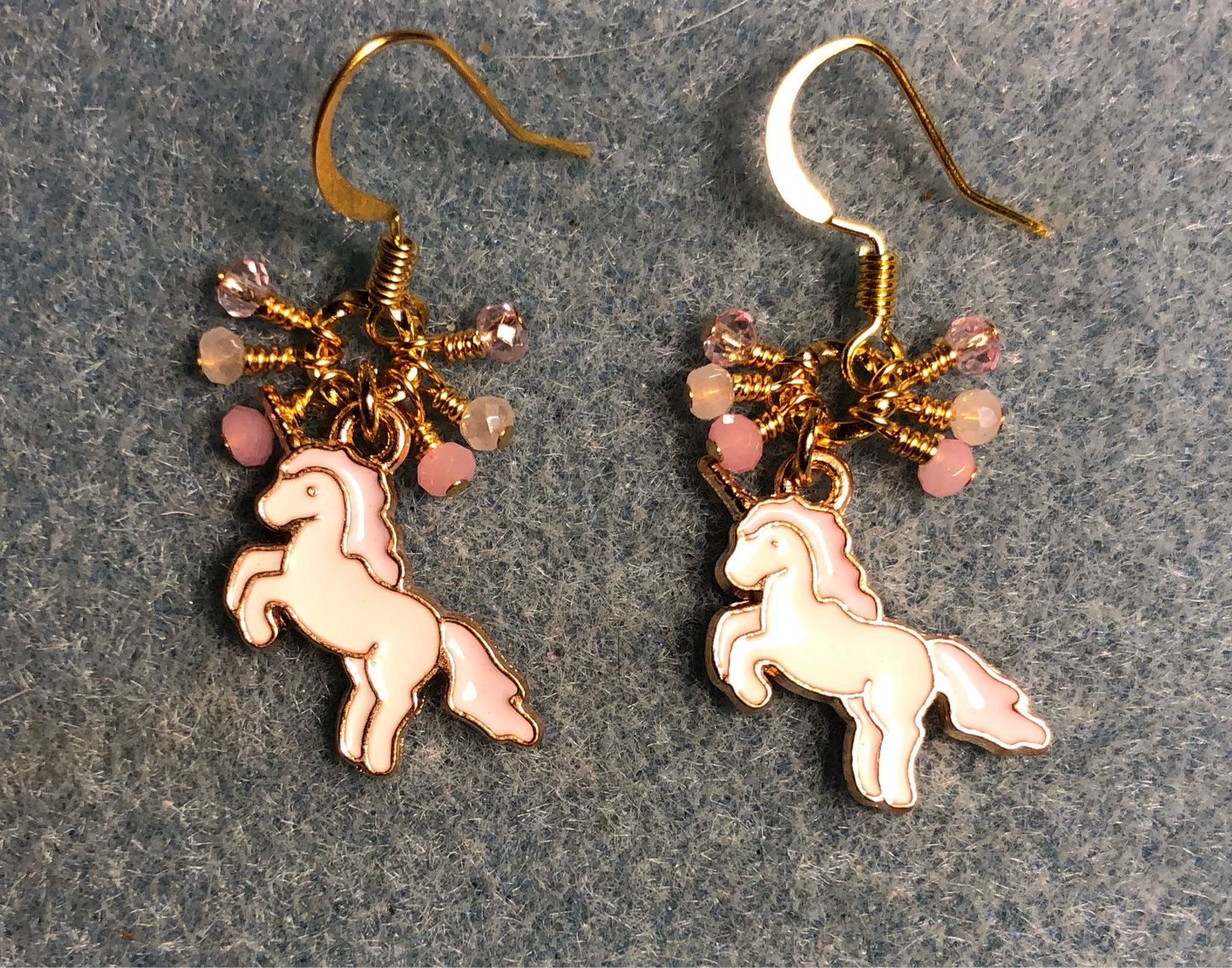 Small pink and white enamel unicorn charm earrings adorned with tiny dangling pink and white Chinese crystal beads.