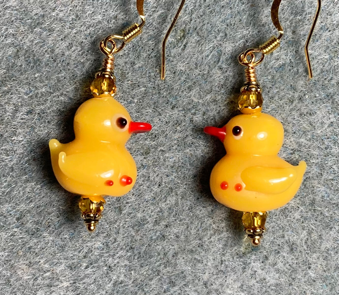 Small golden yellow lamp work duckling bead earrings adorned with amber Chinese crystal beads.