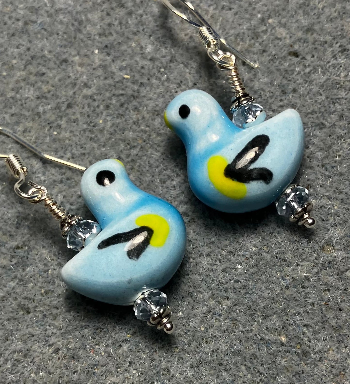 Light blue, black, and yellow ceramic duck bead earrings adorned with light blue Chinese crystal beads.