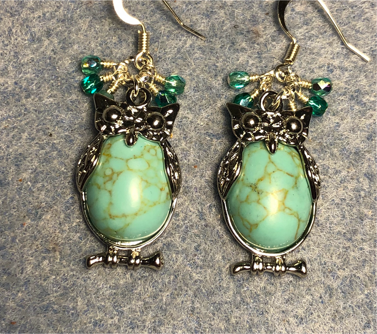 Large silver and turquoise howlite gemstone owl charm earrings adorned with small dangling turquoise Czech glass beads.