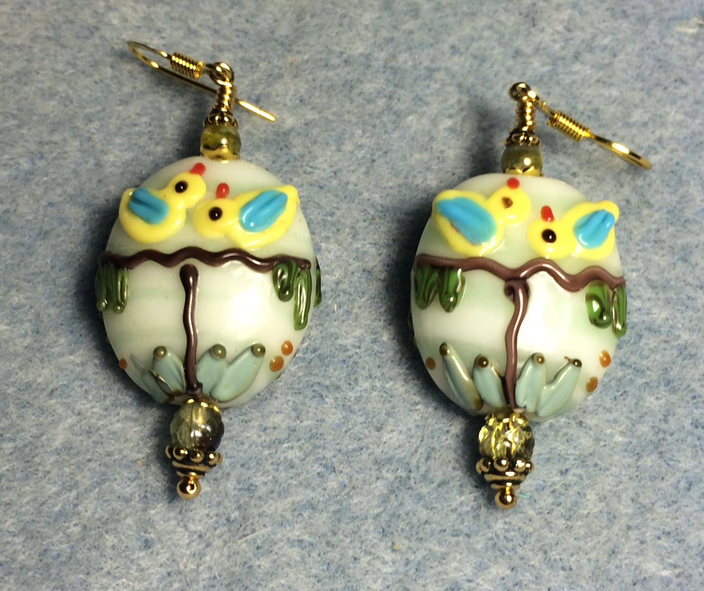Yellow, green, and brown lamp work bird in a tree bead earrings adorned with green Czech glass beads.