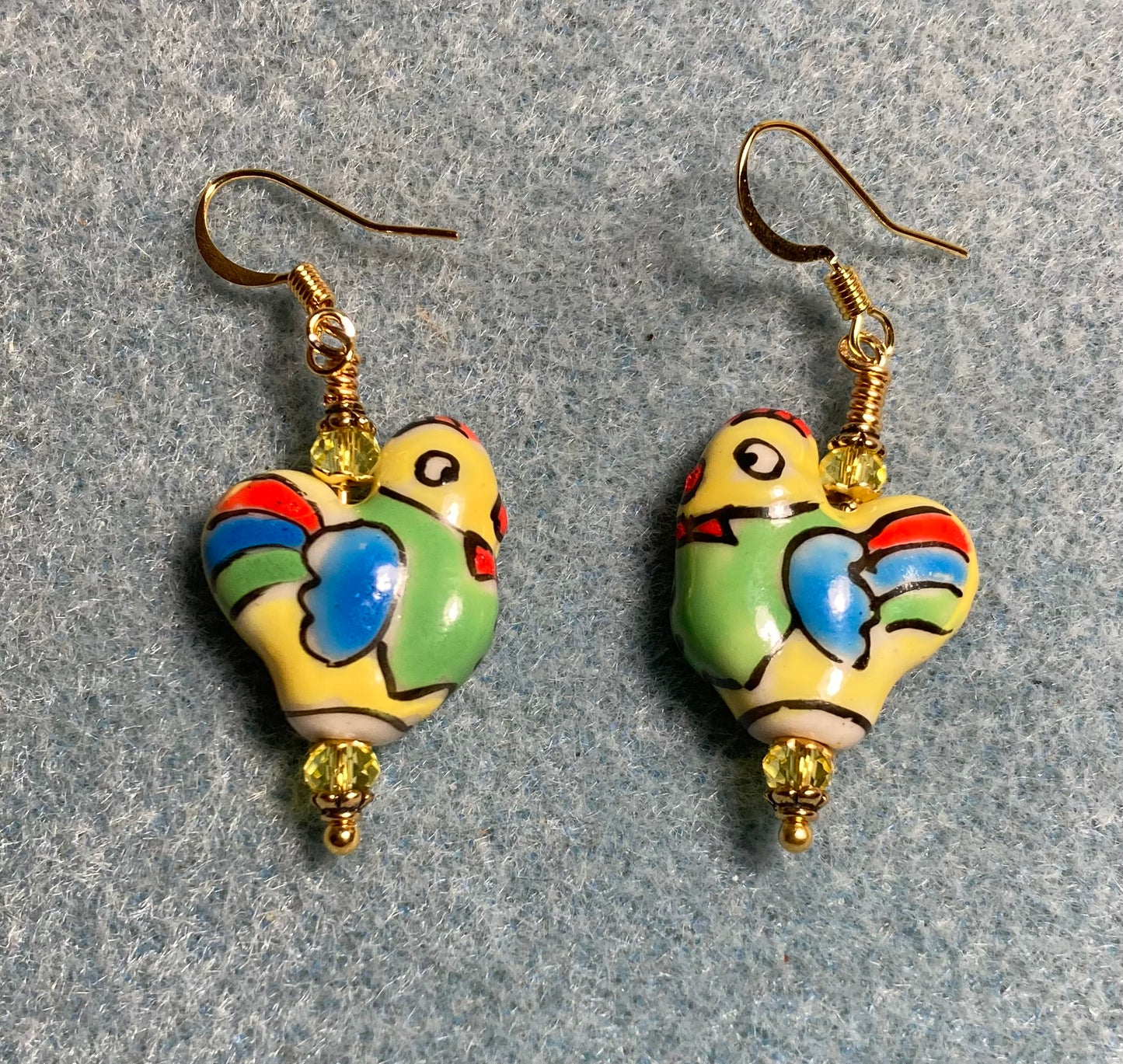 Yellow, green, and blue ceramic chicken bead earrings adorned with yellow Chinese crystal beads.