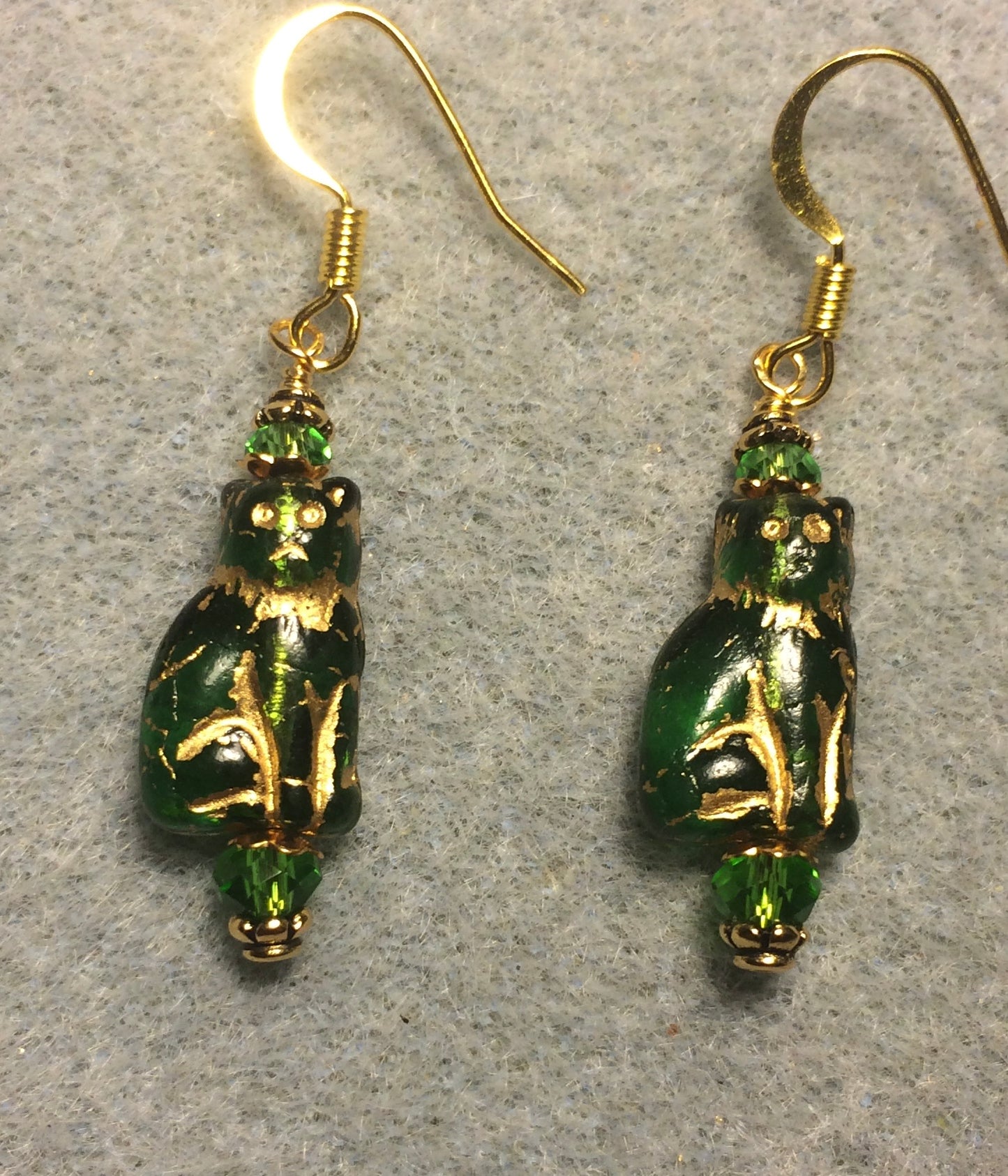 Small translucent emerald green and gold Czech glass cat bead earrings adorned with emerald green Chinese crystal beads.