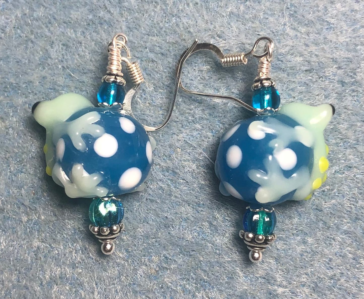 Turquoise, white, and light green lamp work frog bead earrings adorned with turquoise Czech glass beads.