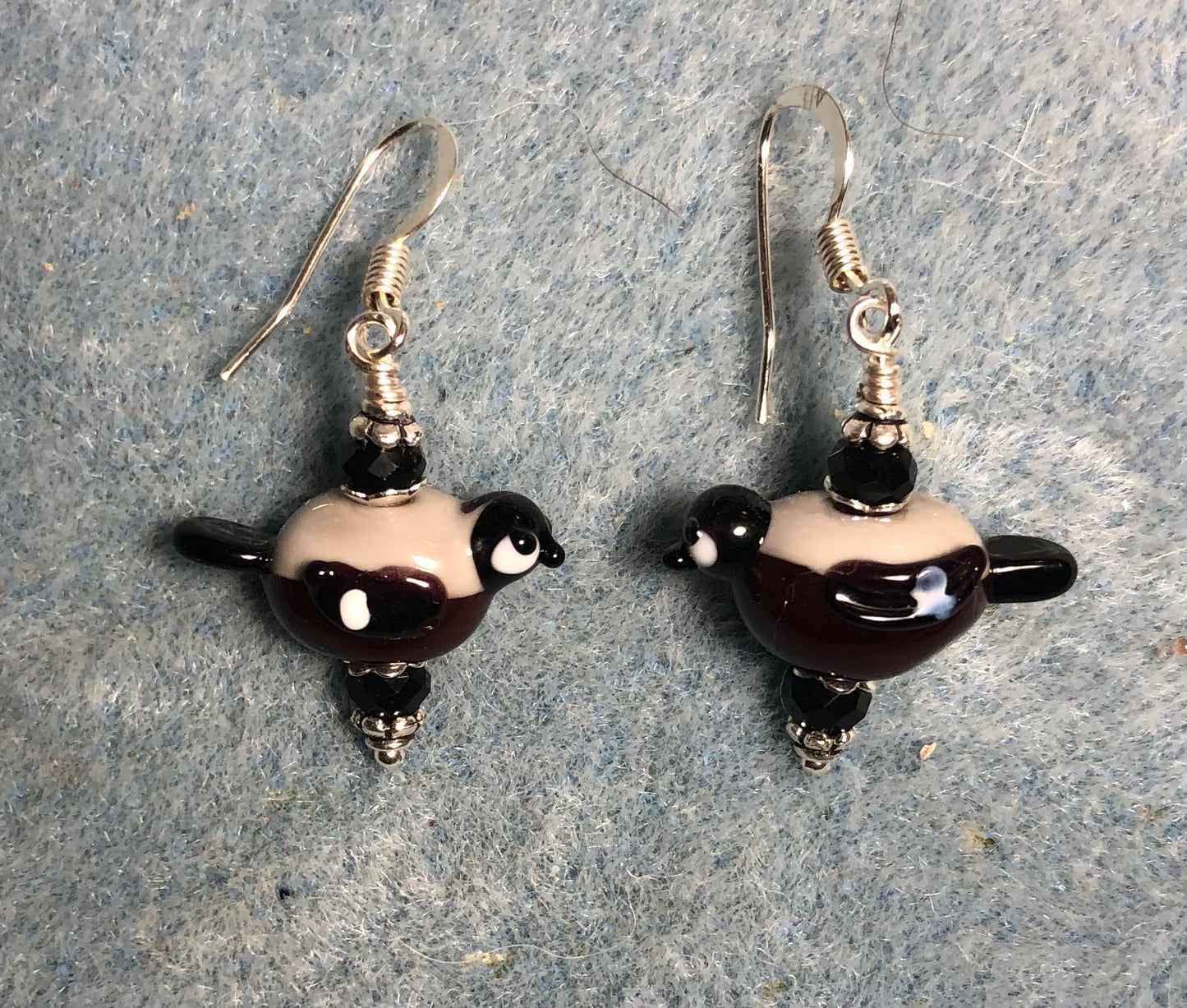 Small black and tan lamp work bullfinch bird bead earrings adorned with black Chinese crystal beads.