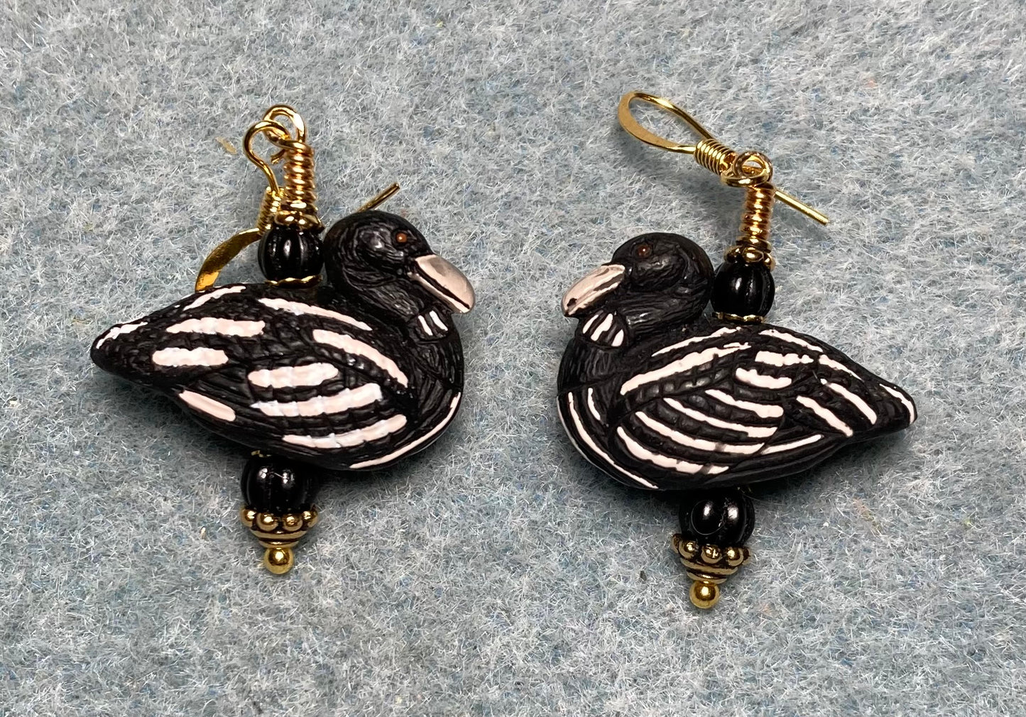 Black and white ceramic striped duck bead earrings adorned with black Czech glass beads.