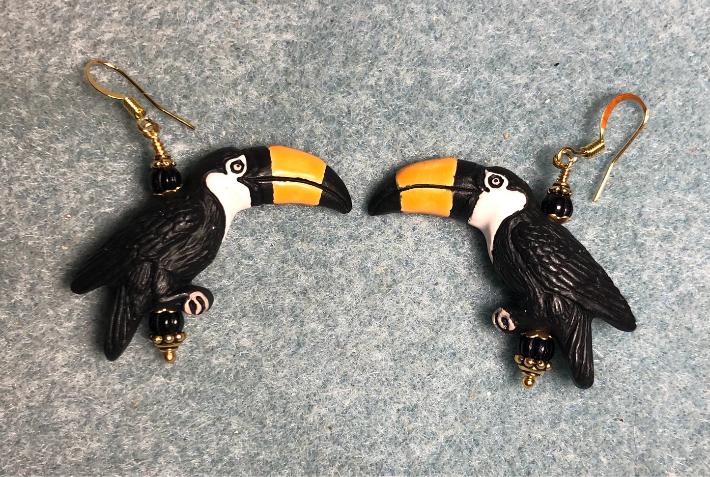 Large black (with amber beaks) ceramic toucan bead earrings adorned with black Czech glass beads.