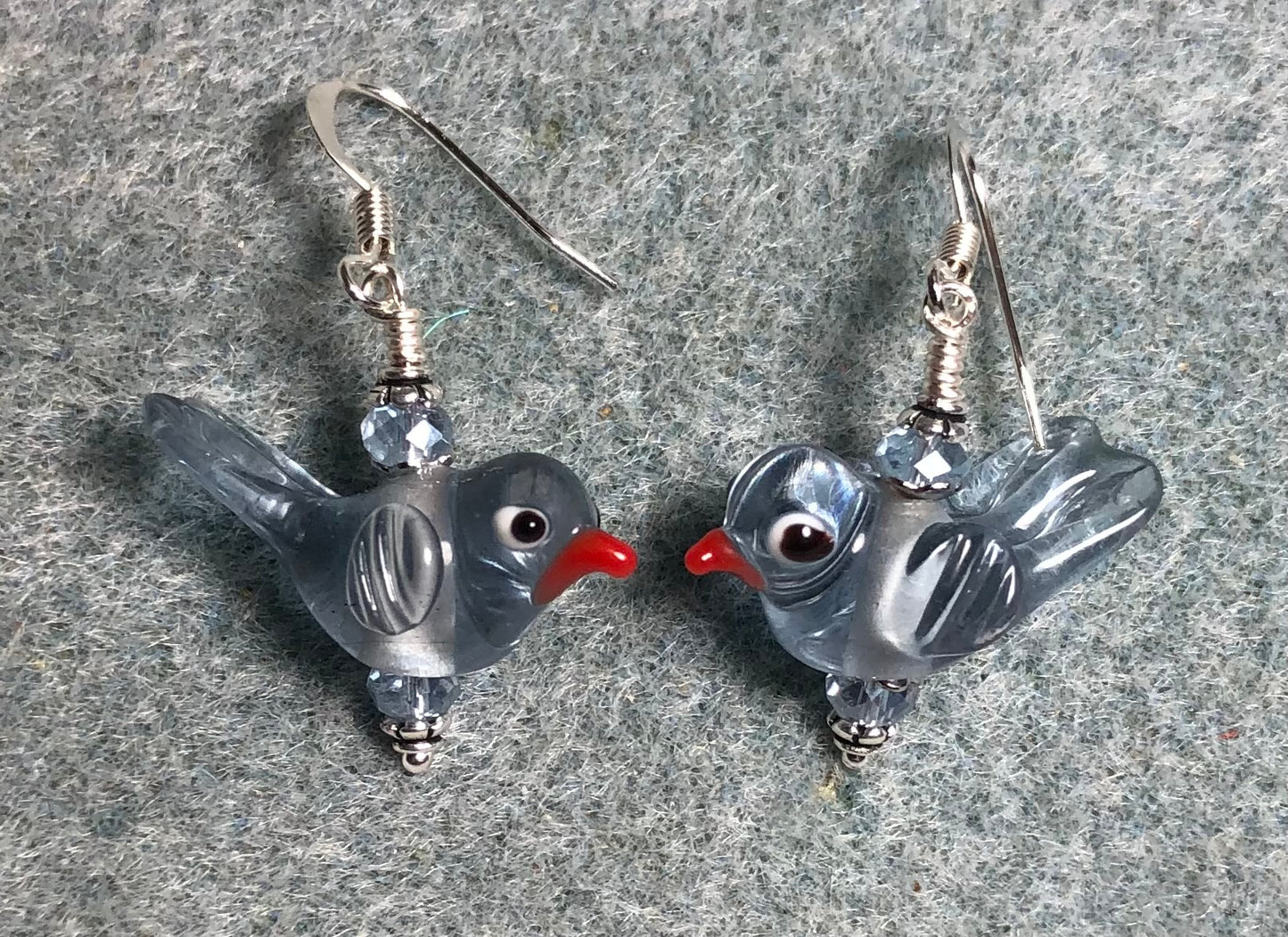 Translucent light blue lamp work songbird bead earrings adorned with light blue Chinese crystal beads.