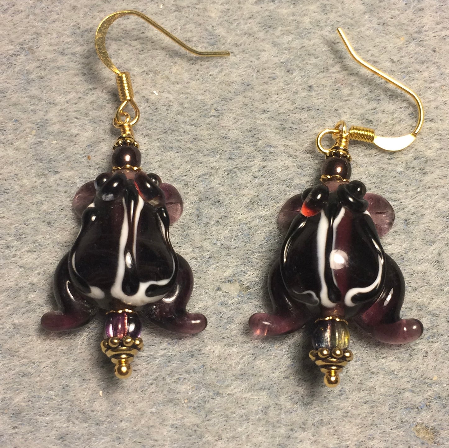 Dark purple lamp work striped frog bead earrings adorned with dark purple Czech glass beads.