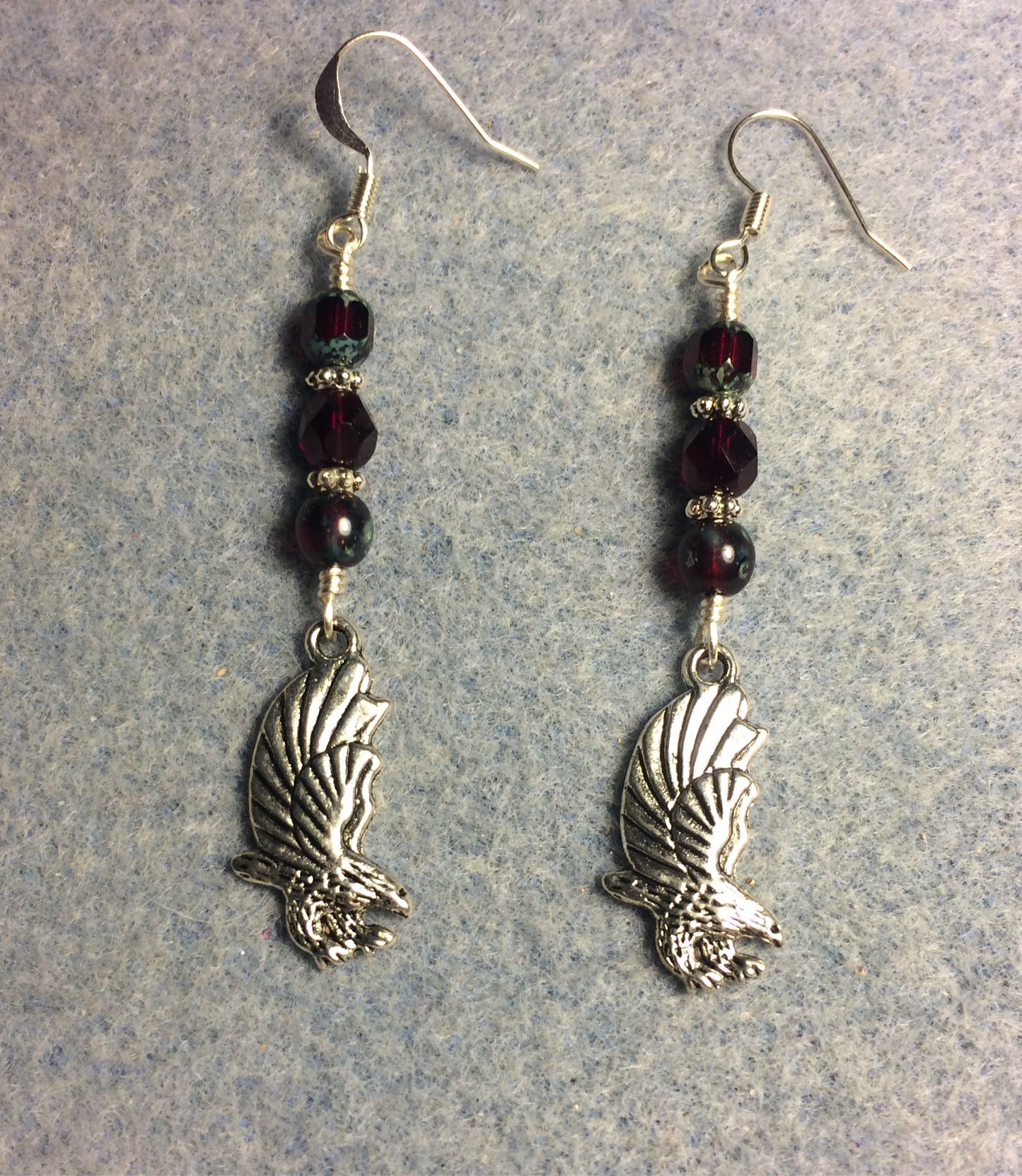 Silver flying eagle charm earrings adorned with ruby red Czech glass beads