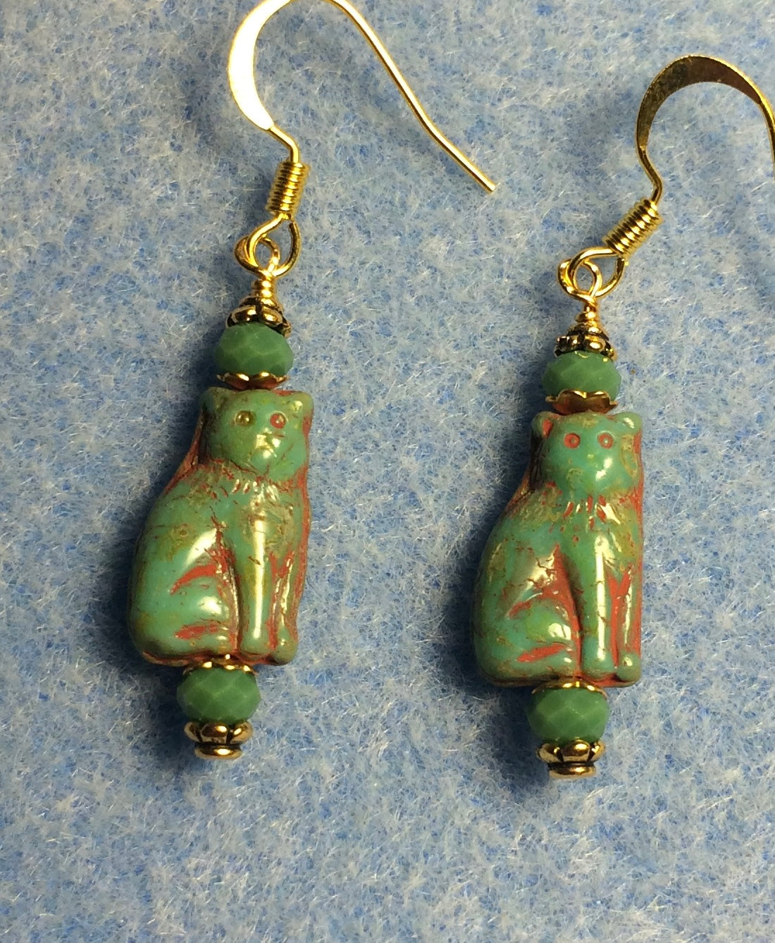 Small opaque green Czech glass cat bead earrings adorned with green Chinese crystal beads.
