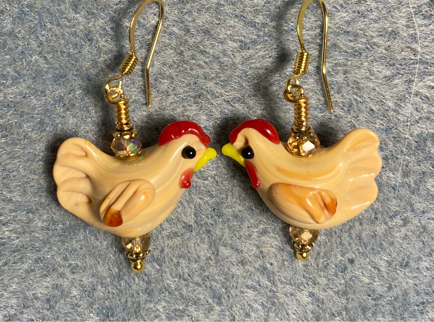 Light tan lamp work chicken bead earrings adorned with amber Chinese crystal beads.