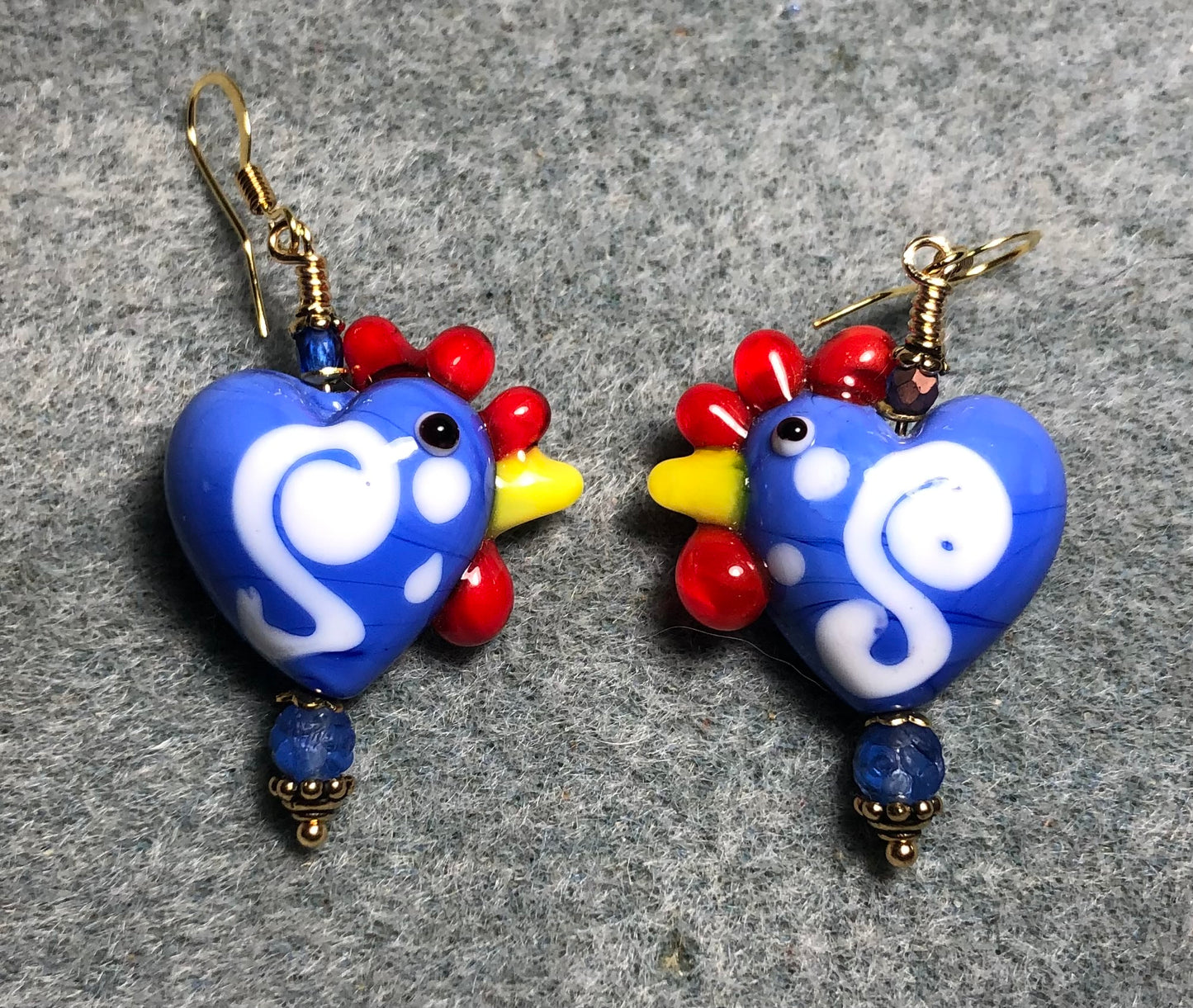 Opaque blue and red heart shaped lamp work hen bead earrings adorned with blue Czech glass beads.