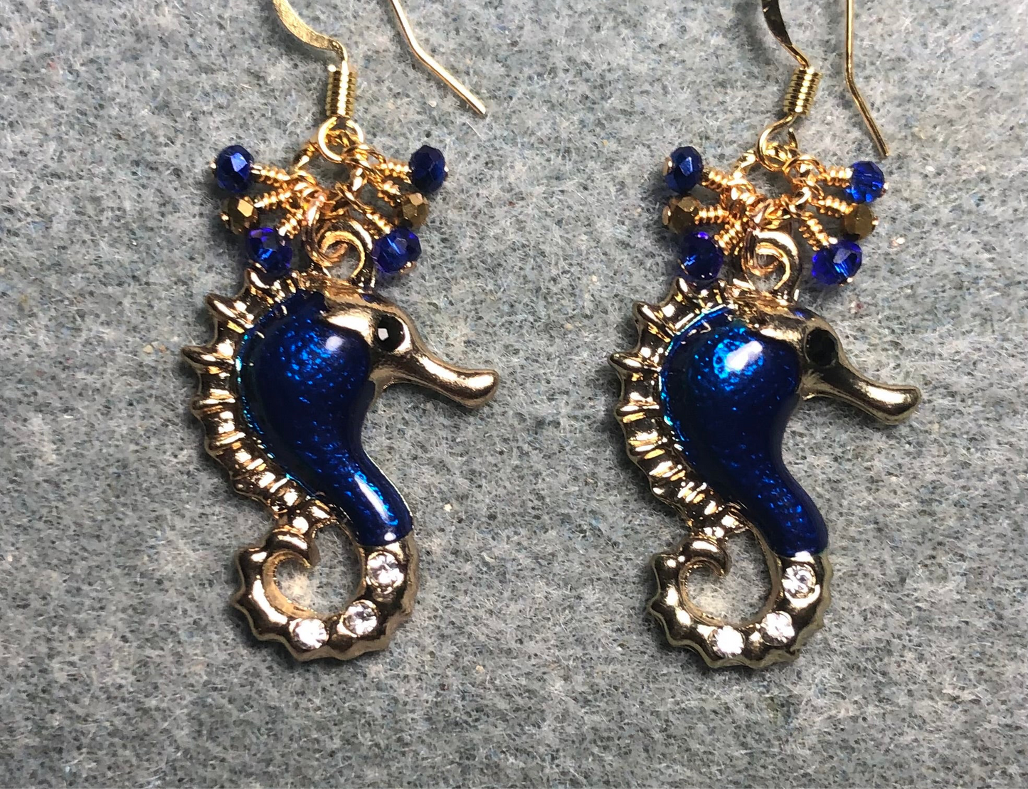 Dark blue enamel and rhinestone seahorse charm earrings adorned with tiny dangling dark blue and gold Chinese crystal beads.