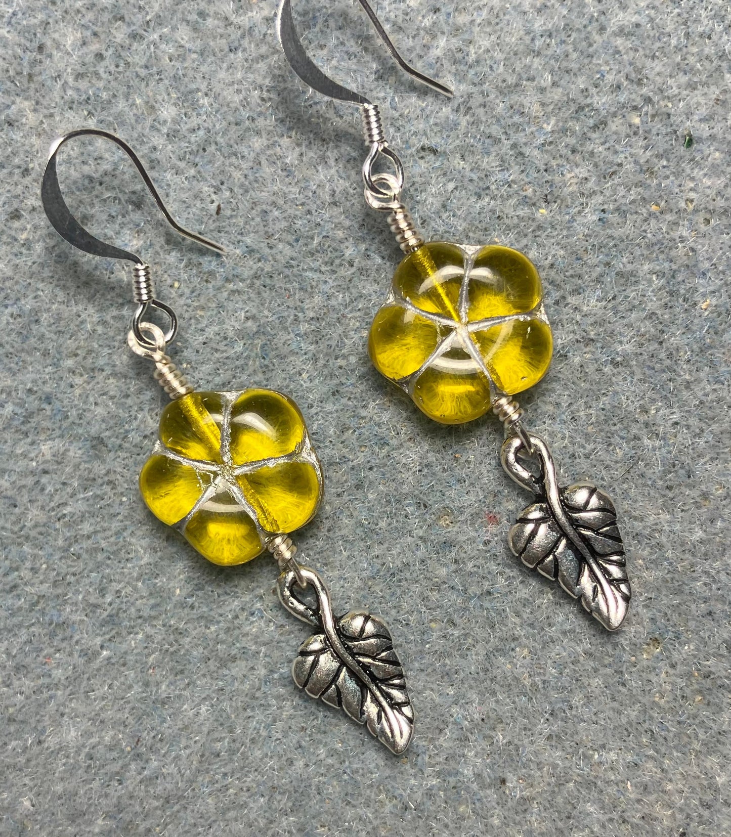 Yellow (with silver inlay) Czech glass puffy flower bead earrings adorned with silver Tierracast leaf charms.