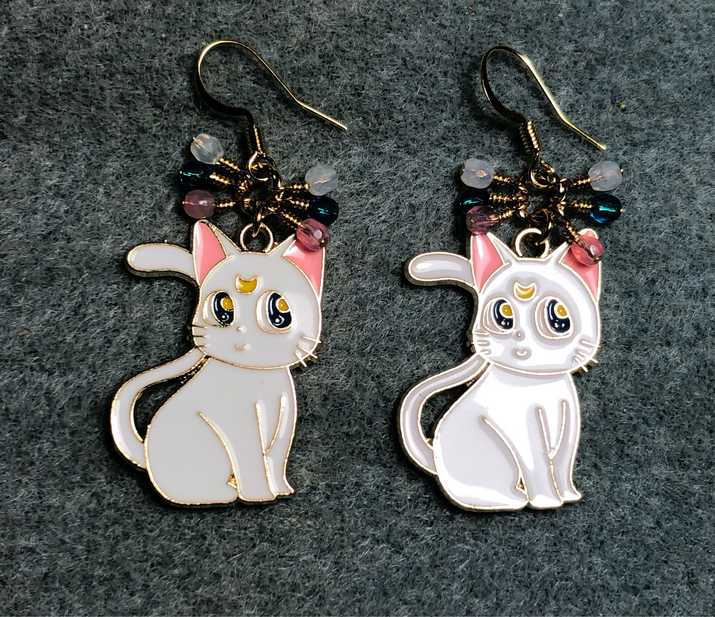 White and pink enamel cat charm earrings adorned with tiny dangling white, pink, and turquoise Czech glass beads.