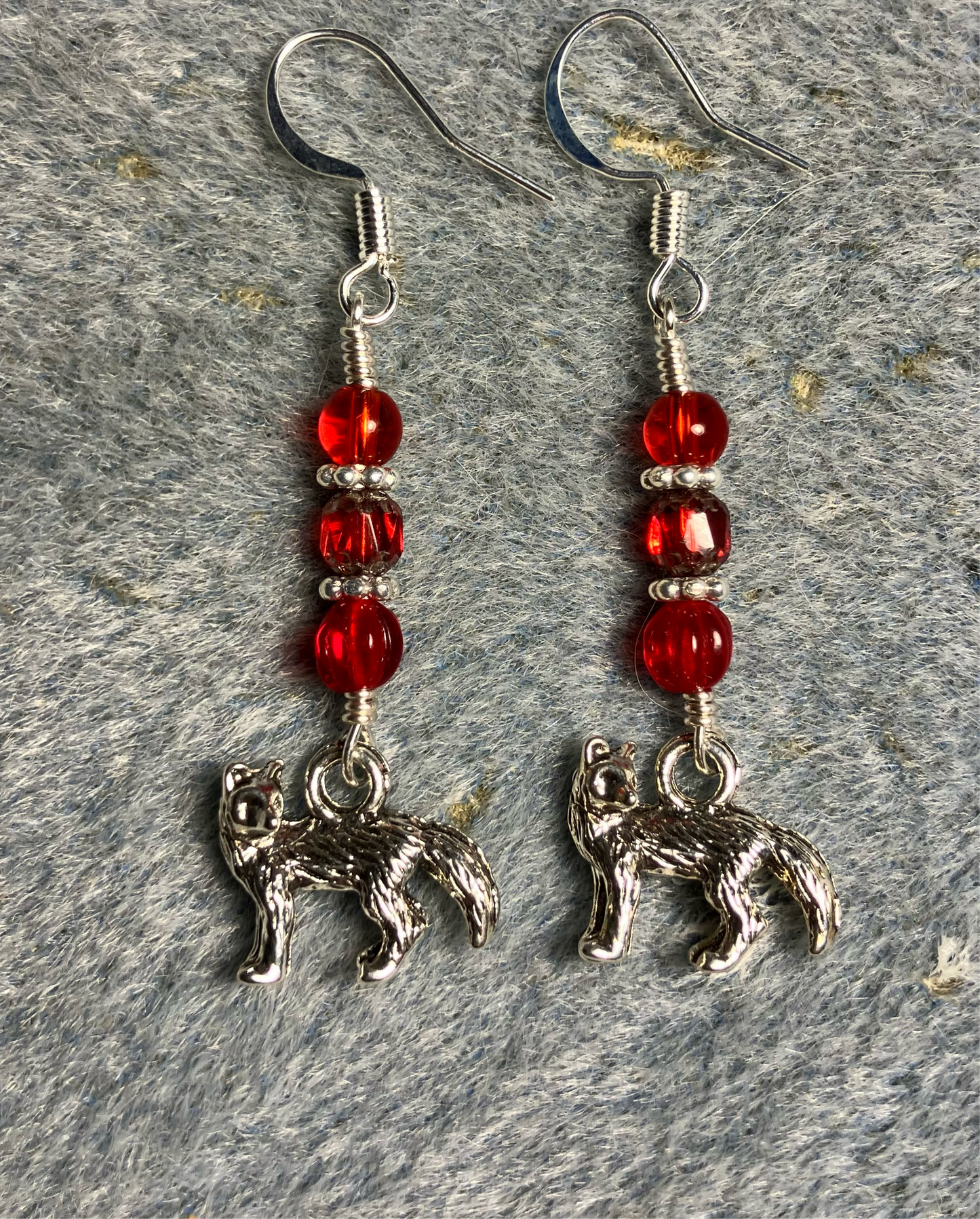 Silver fox charm earrings adorned with small red Czech glass beads.