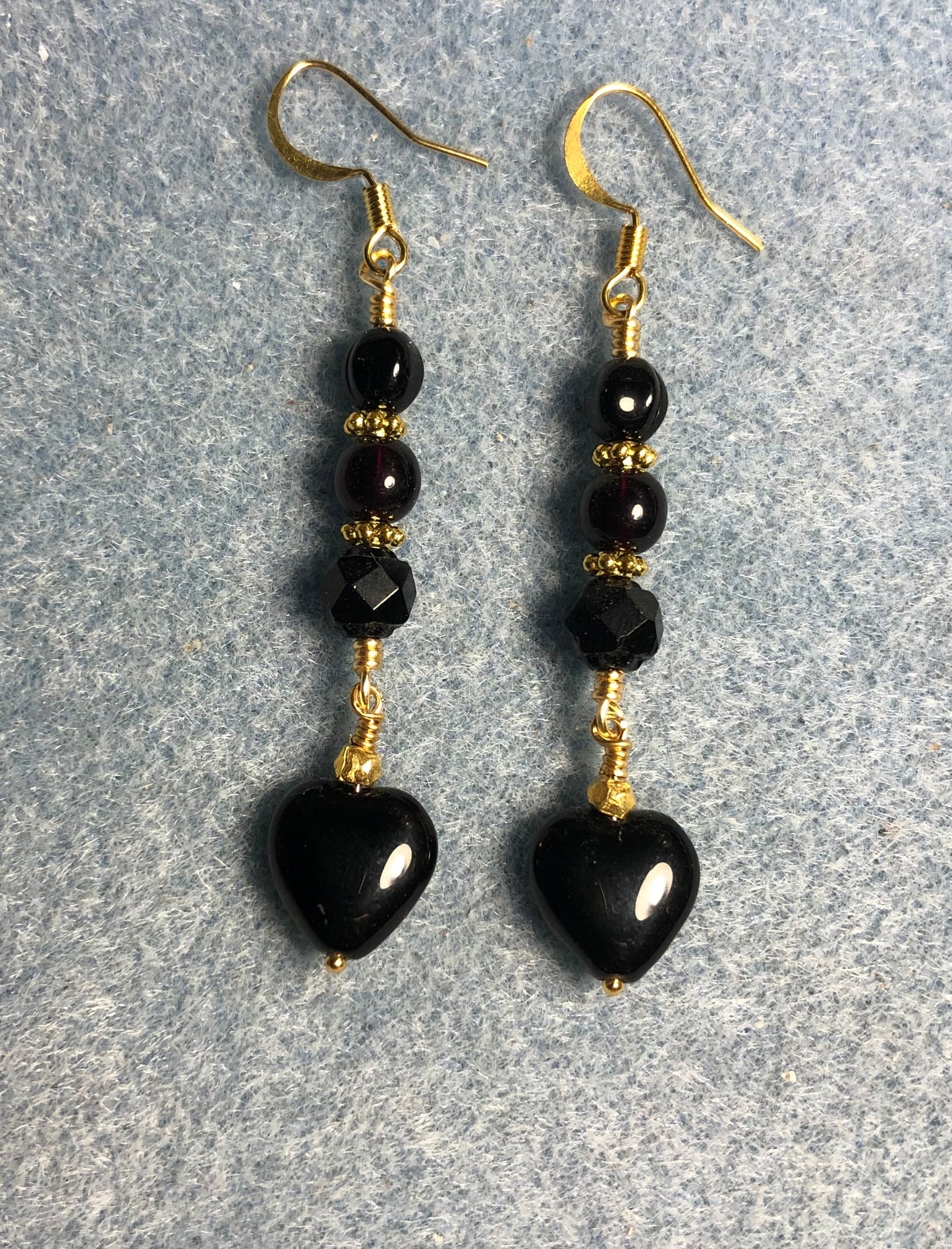 Small black Czech glass heart bead earrings adorned with black Czech glass beads.