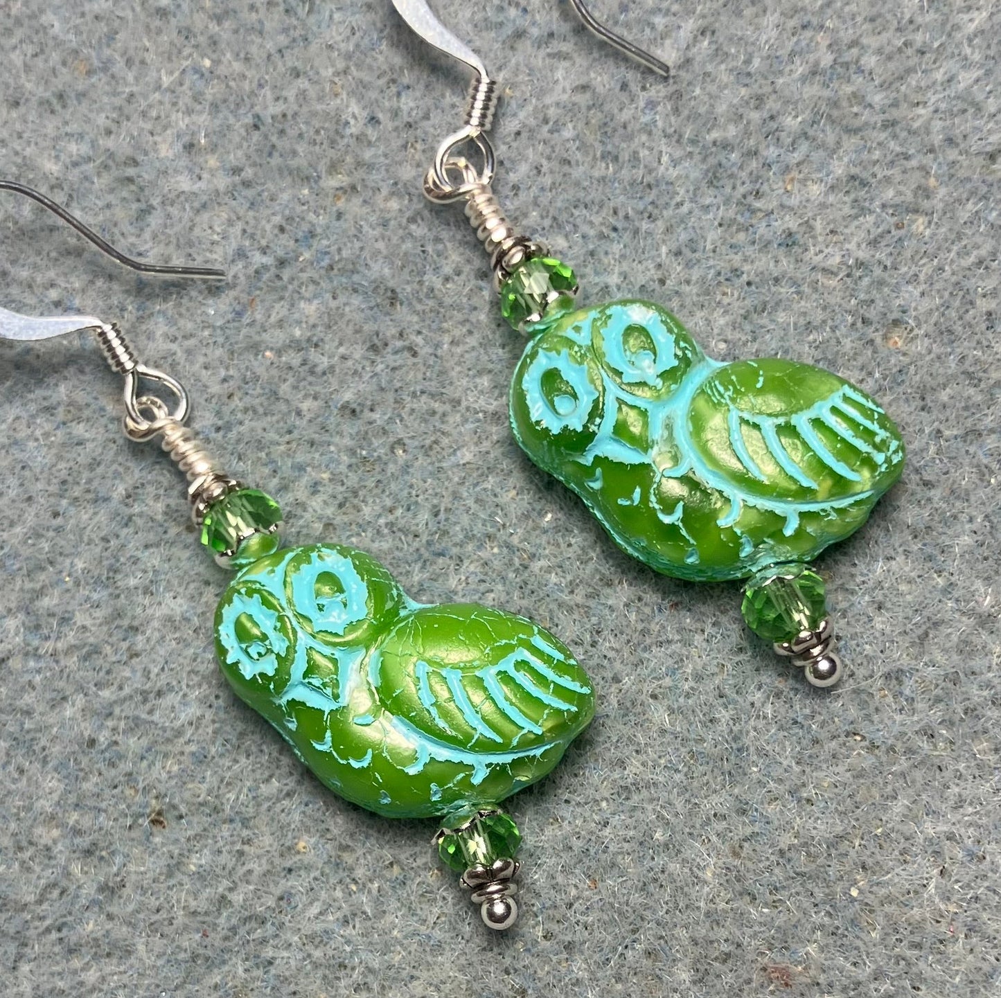 Light green (with turquoise inlay) fancy Czech glass owl bead earrings adorned with light green Chinese crystal beads.