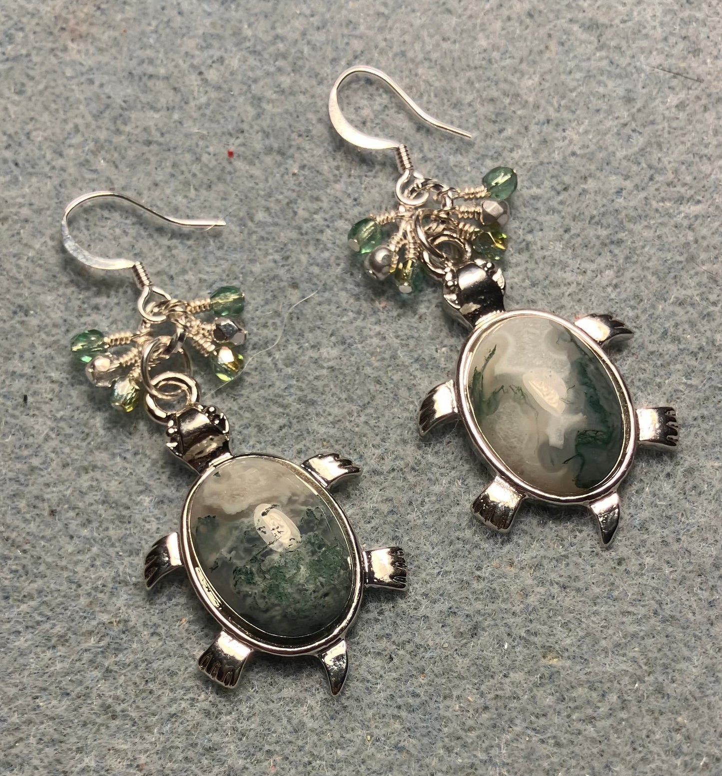 Large silver and green Indian agate gemstone turtle charm earrings adorned with small dangling green and silver Czech glass beads.