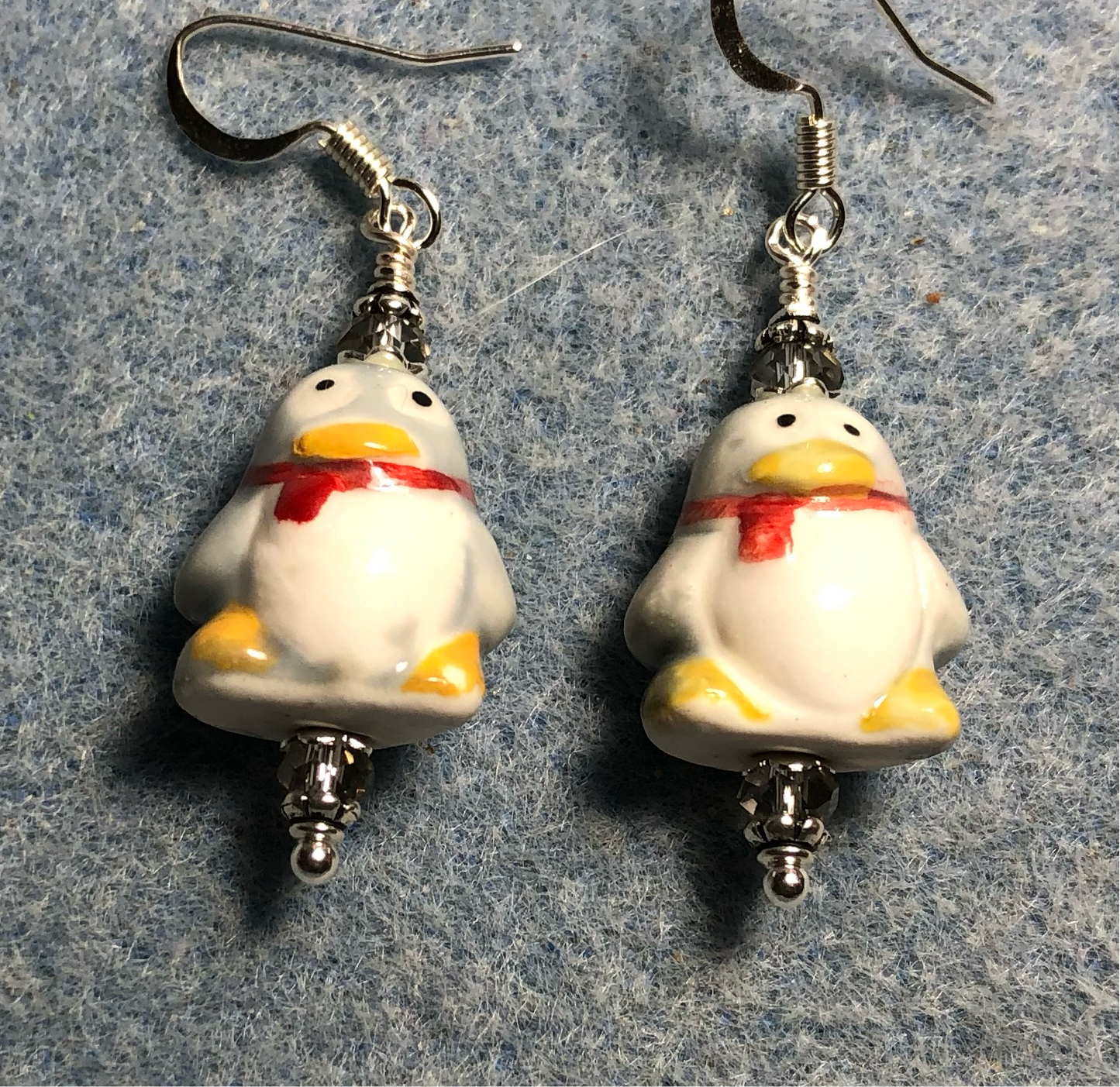 Gray, white, yellow, and red ceramic penguin bead earrings adorned with gray Chinese crystal beads.