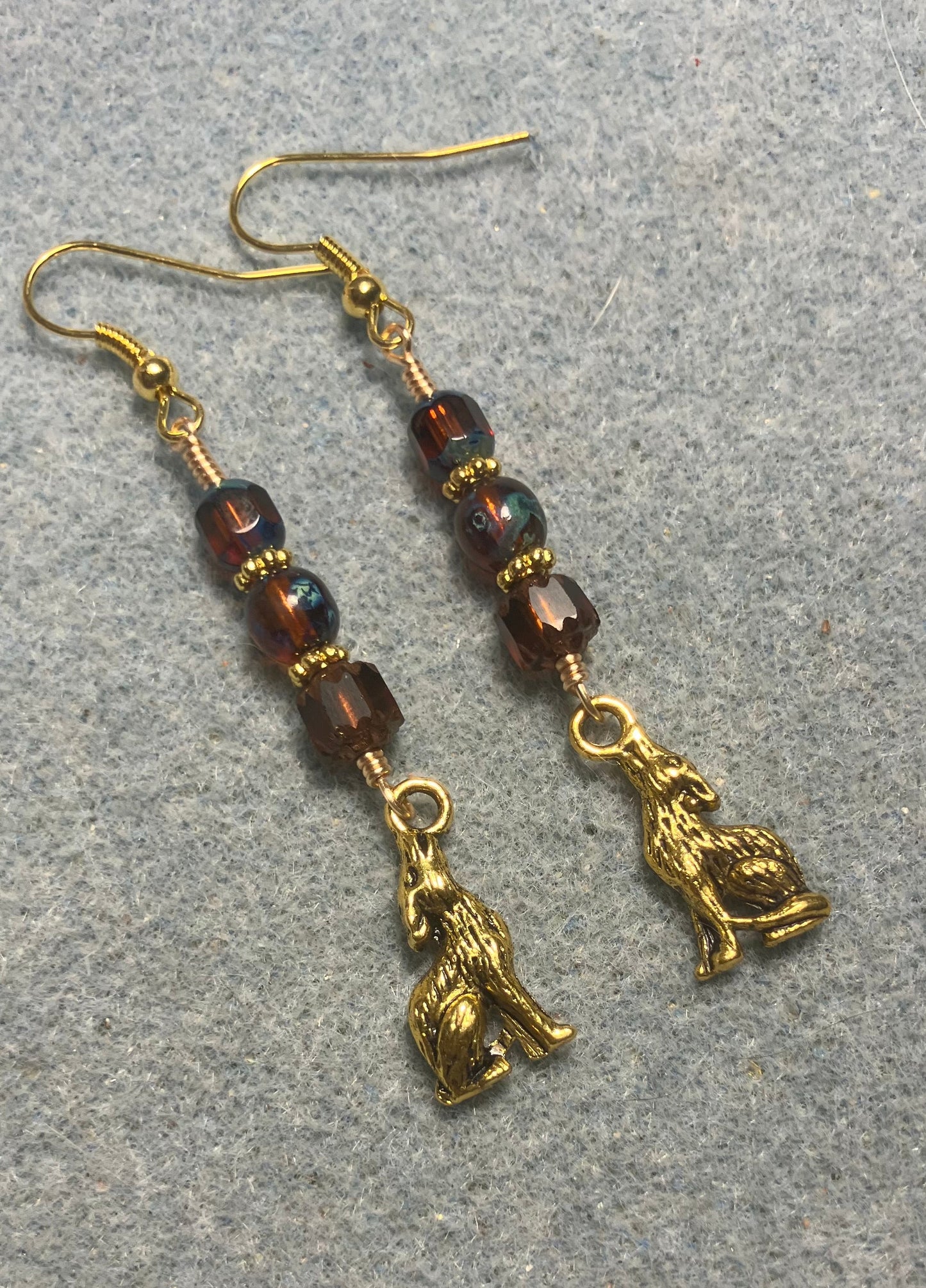 Gold howling coyote charm earrings adorned with brown Czech glass beads