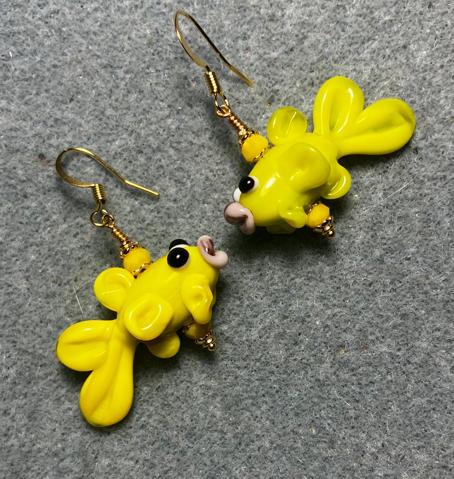 Opaque yellow lamp work fish bead earrings adorned with opaque yellow Chinese crystal beads.