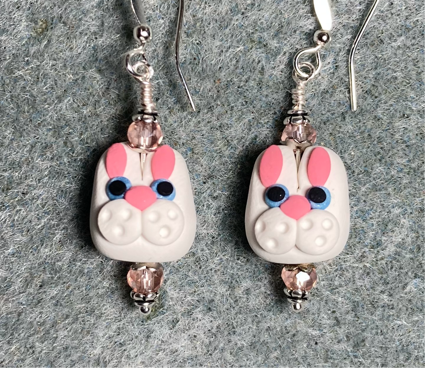 White, pink, and blue polymer clay rabbit bead earrings adorned with pink Chinese crystal beads.