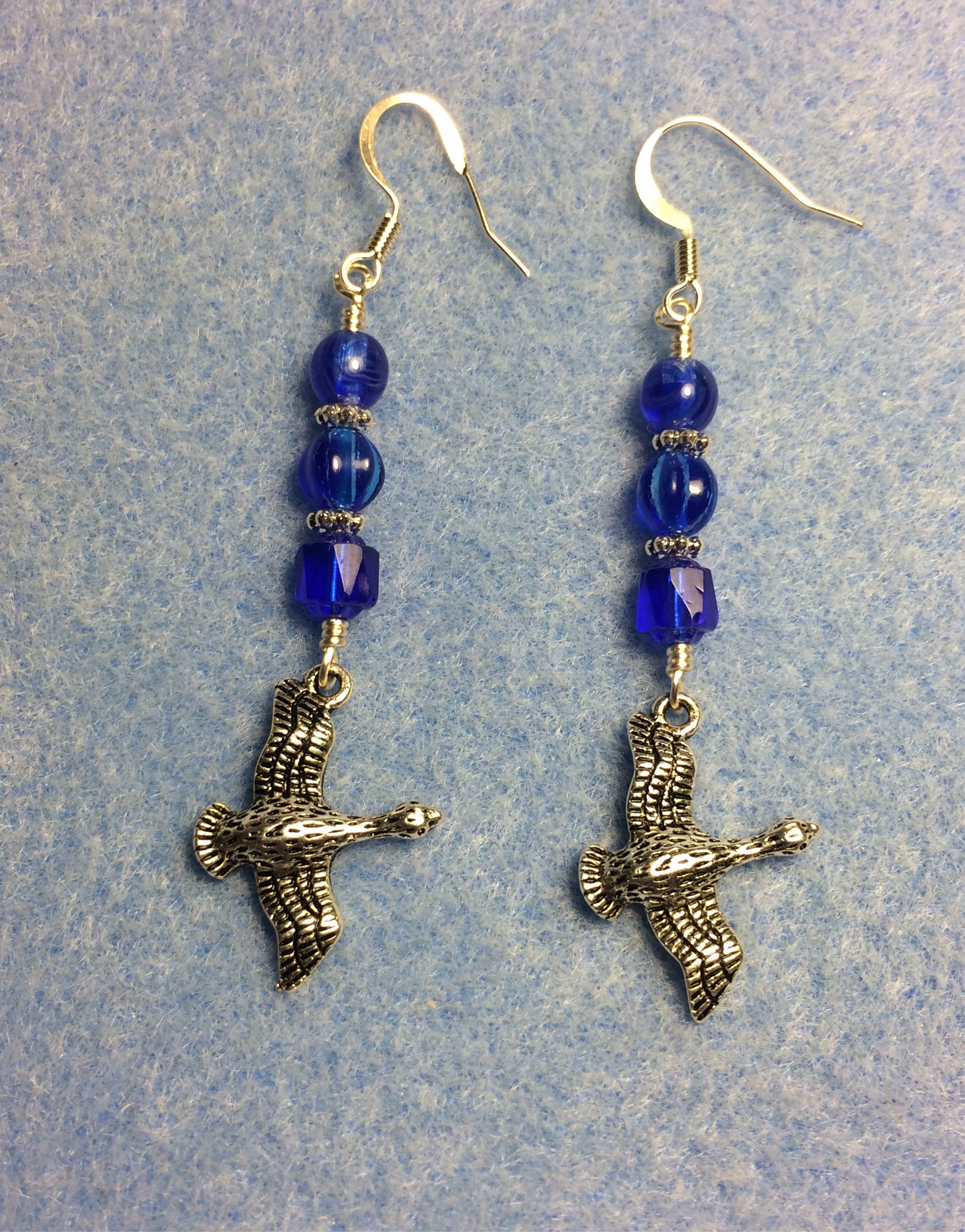 Silver flying geese charm earrings adorned with dark blue Czech glass beads