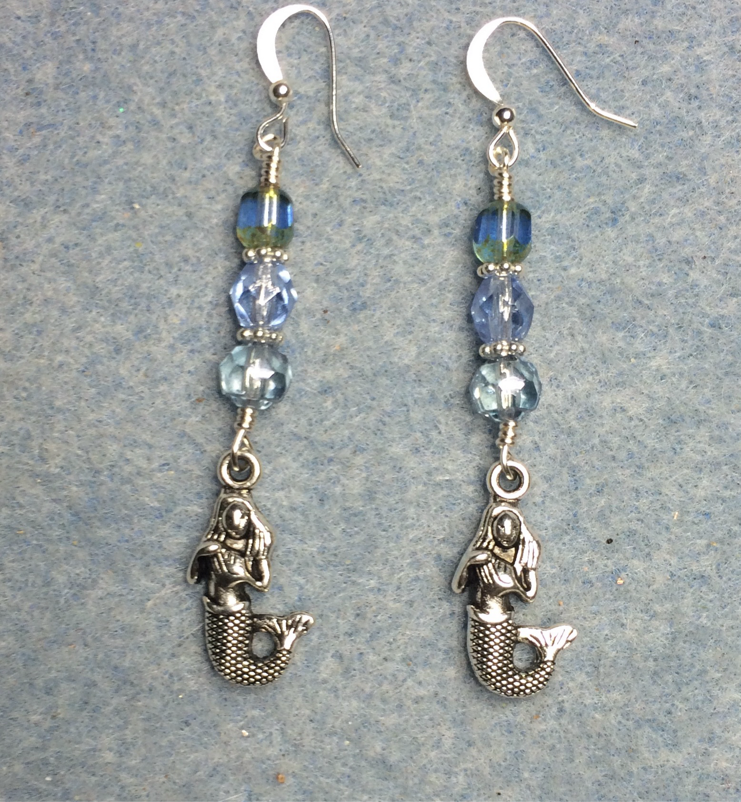 Silver mermaid charm earrings adorned with light blue Czech glass beads