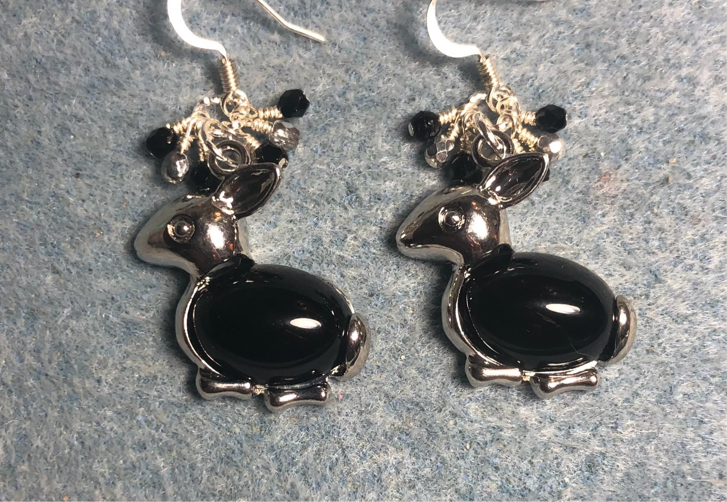 Large silver and black onyx gemstone rabbit charm earrings adorned with small dangling black and silver Czech glass beads.
