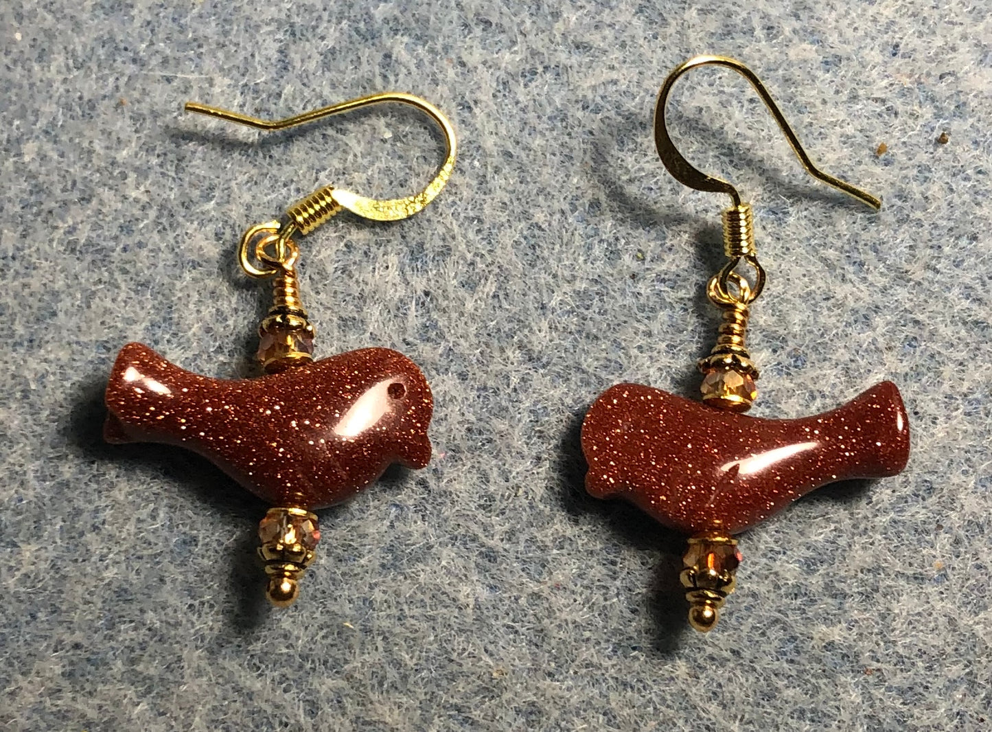 Small orange goldstone gemstone bird bead earrings adorned with small orange Chinese crystal beads.