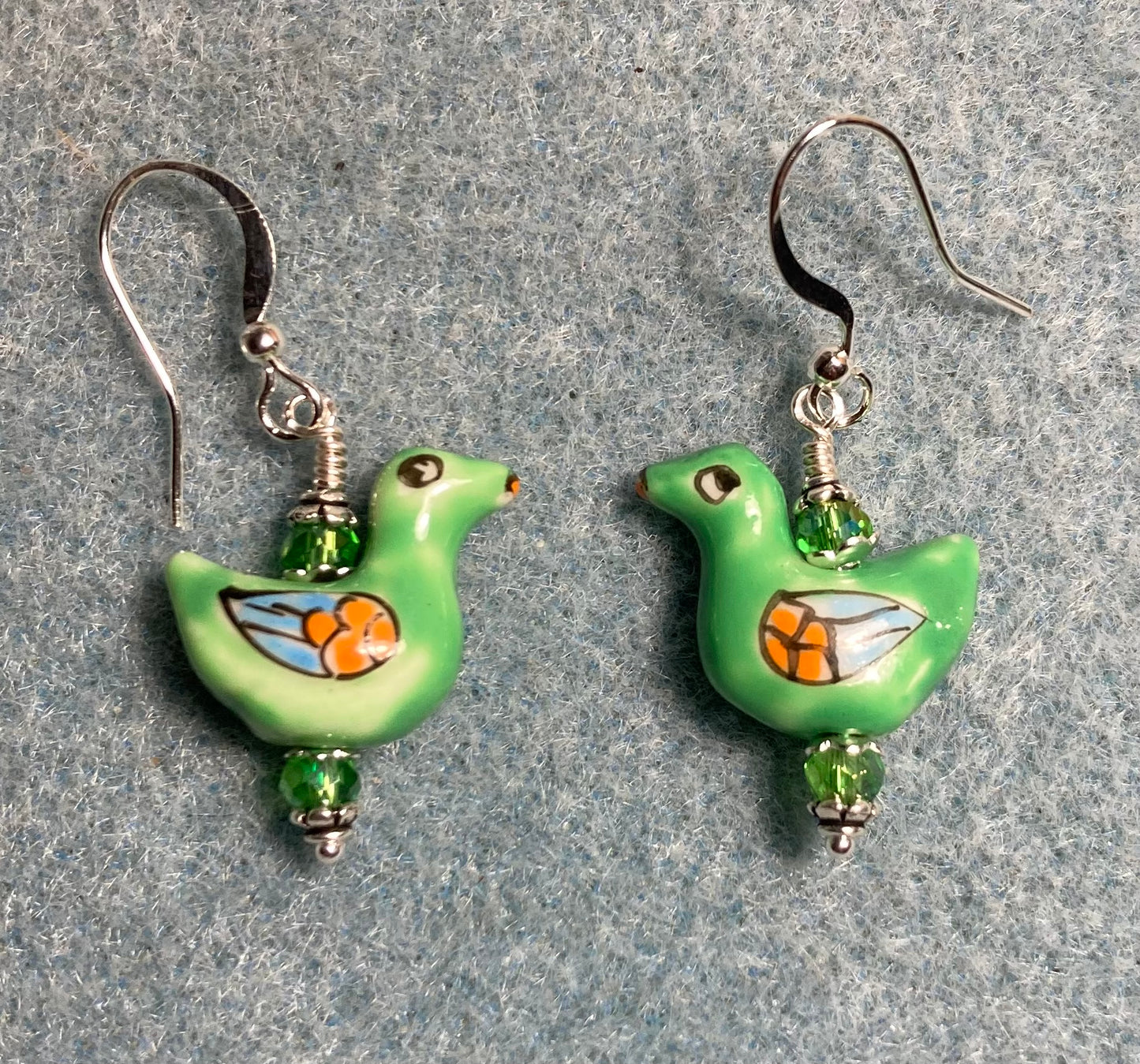 Green, orange, and blue ceramic duck bead earrings adorned with green Chinese crystal beads.