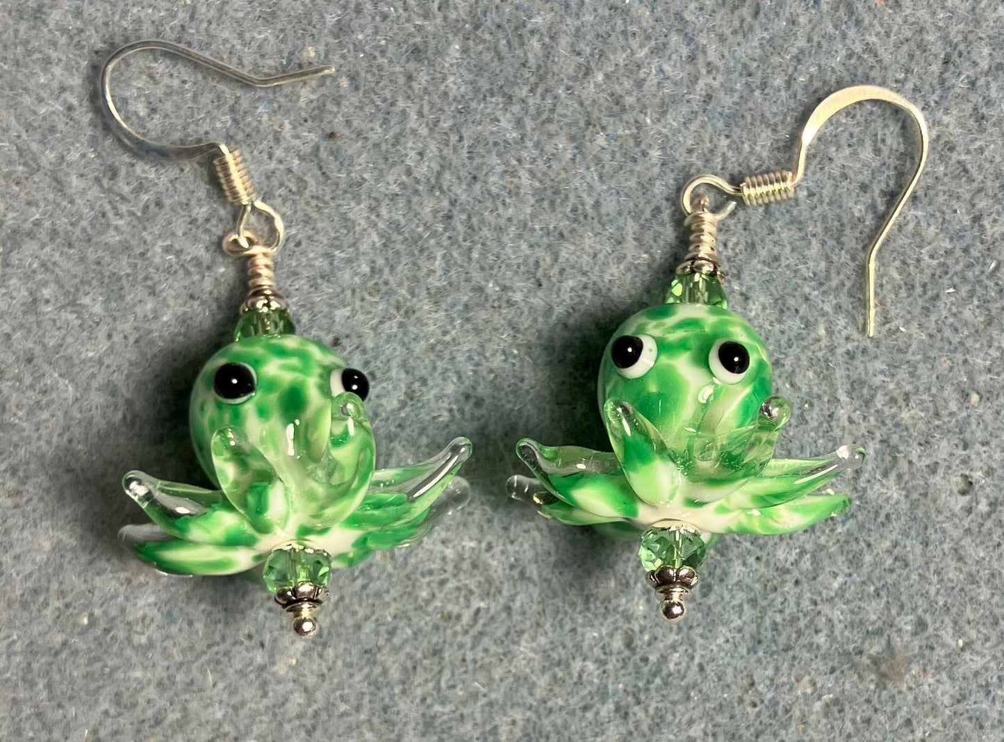 Green and white mottled lamp work octopus bead earrings adorned with green Chinese crystal beads.