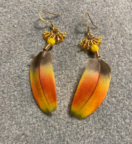 Yellow orange macaw feather earrings adorned with yellow Czech glass beads and tiny dangling amber, orange, and yellow Chinese crystal beads.