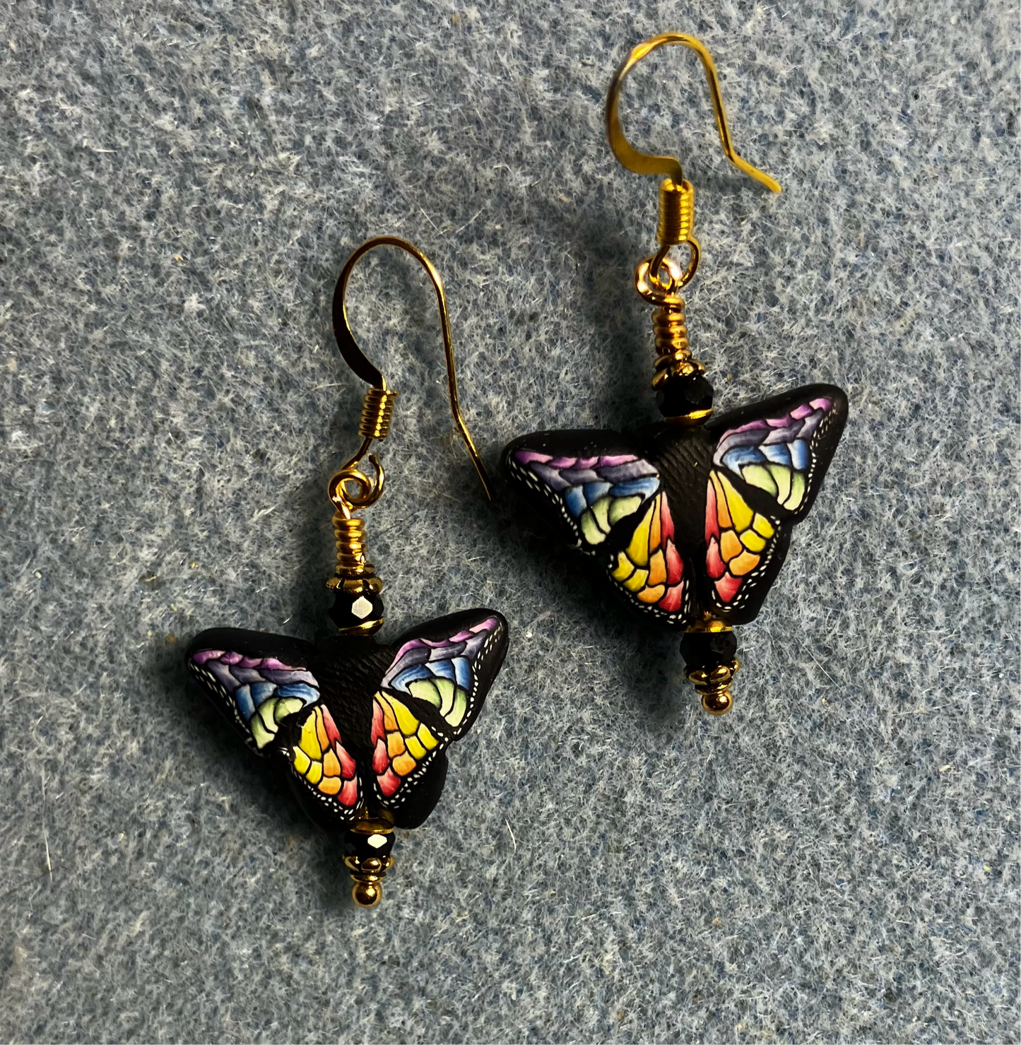 Multicolored polymer clay butterfly bead earrings adorned with black Chinese crystal beads.