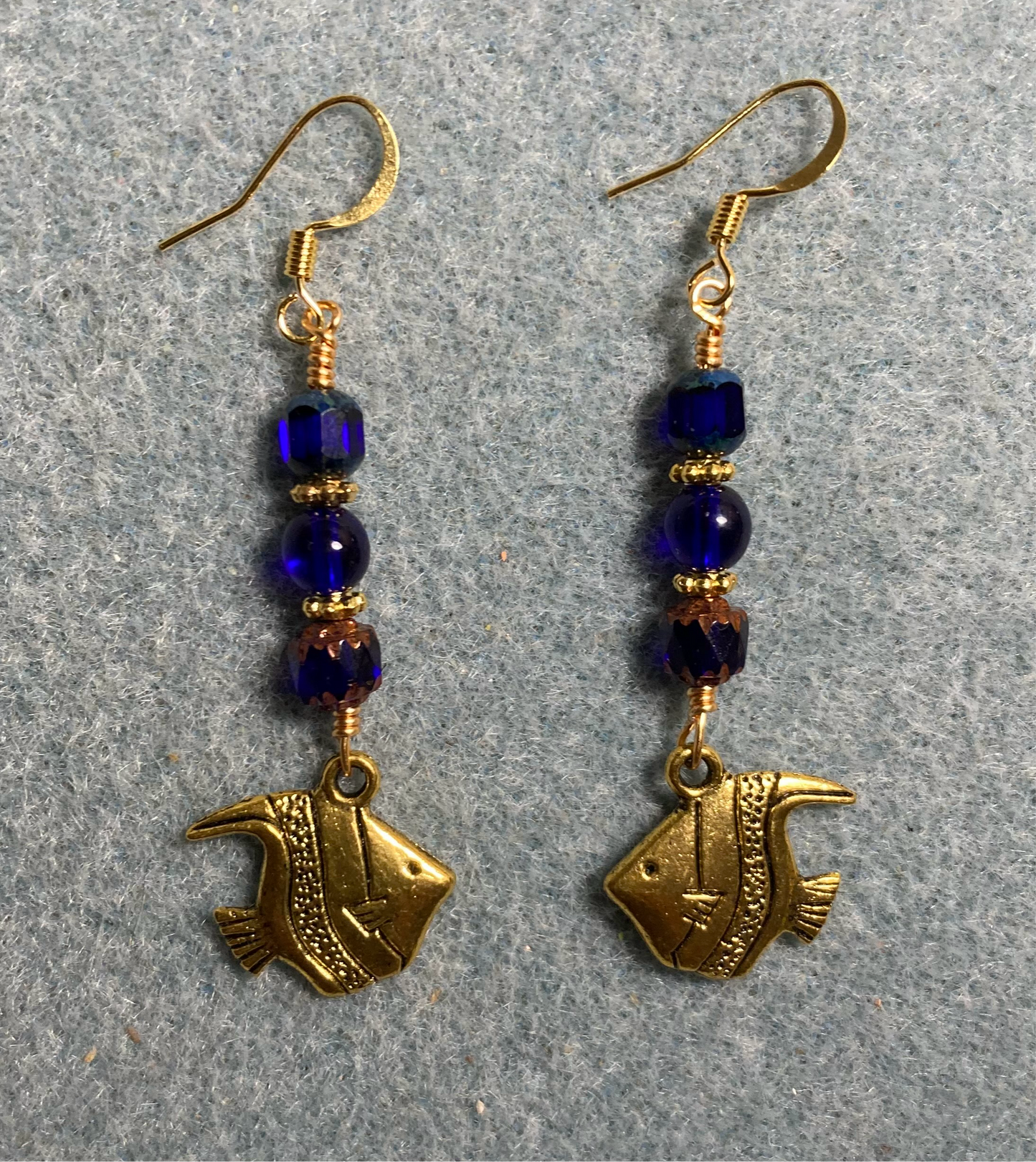 Gold angelfish charm earrings adorned with dark blue Czech glass beads