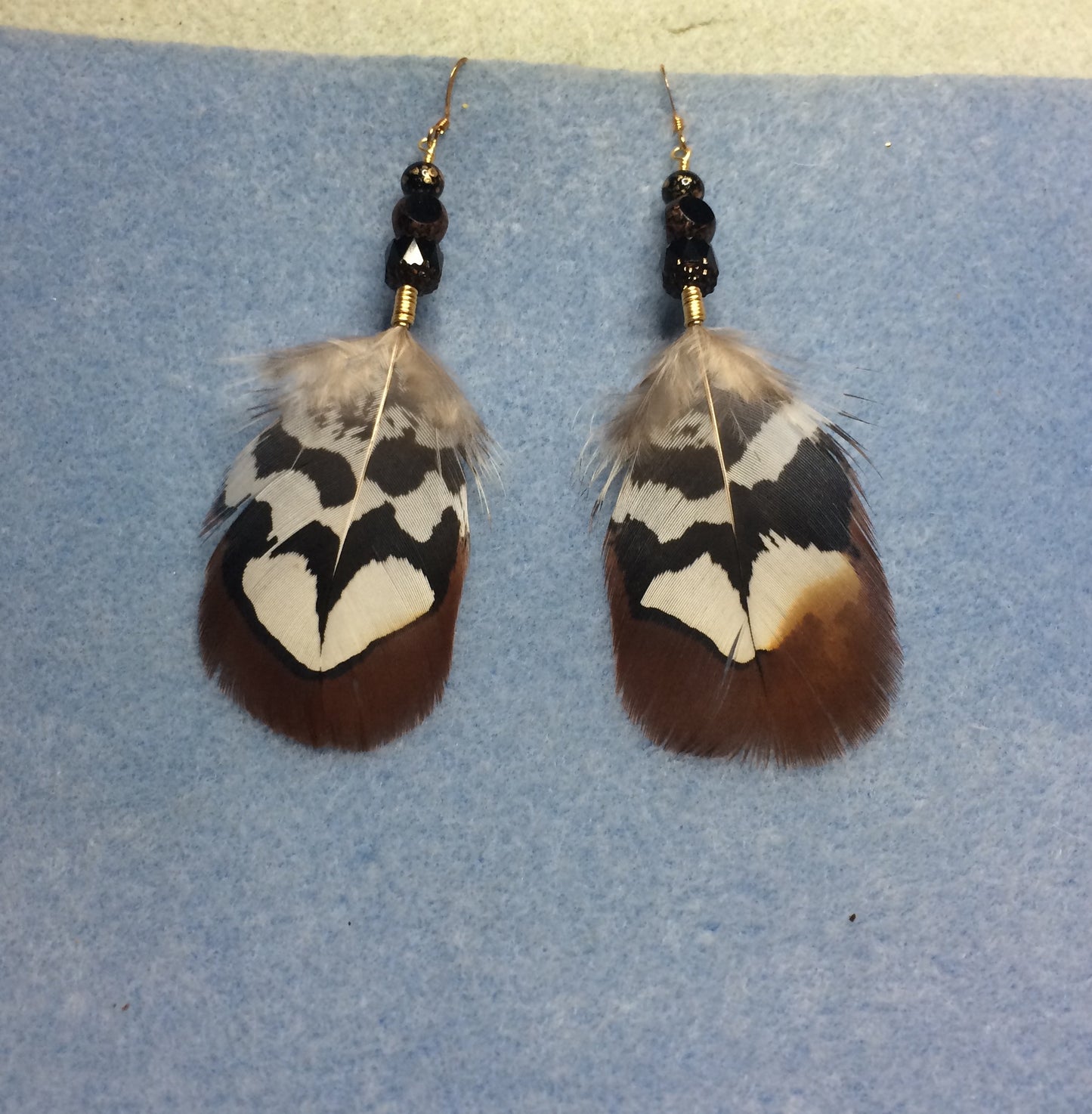 Brown Reeves pheasant feather earrings adorned with black Czech glass beads.