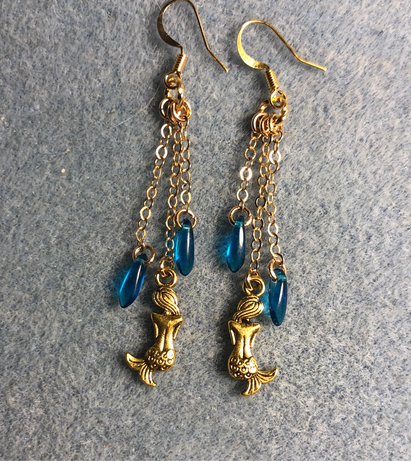 Small gold mermaid charm earrings attached to gold chain and adorned with small turquoise Czech glass dagger beads
